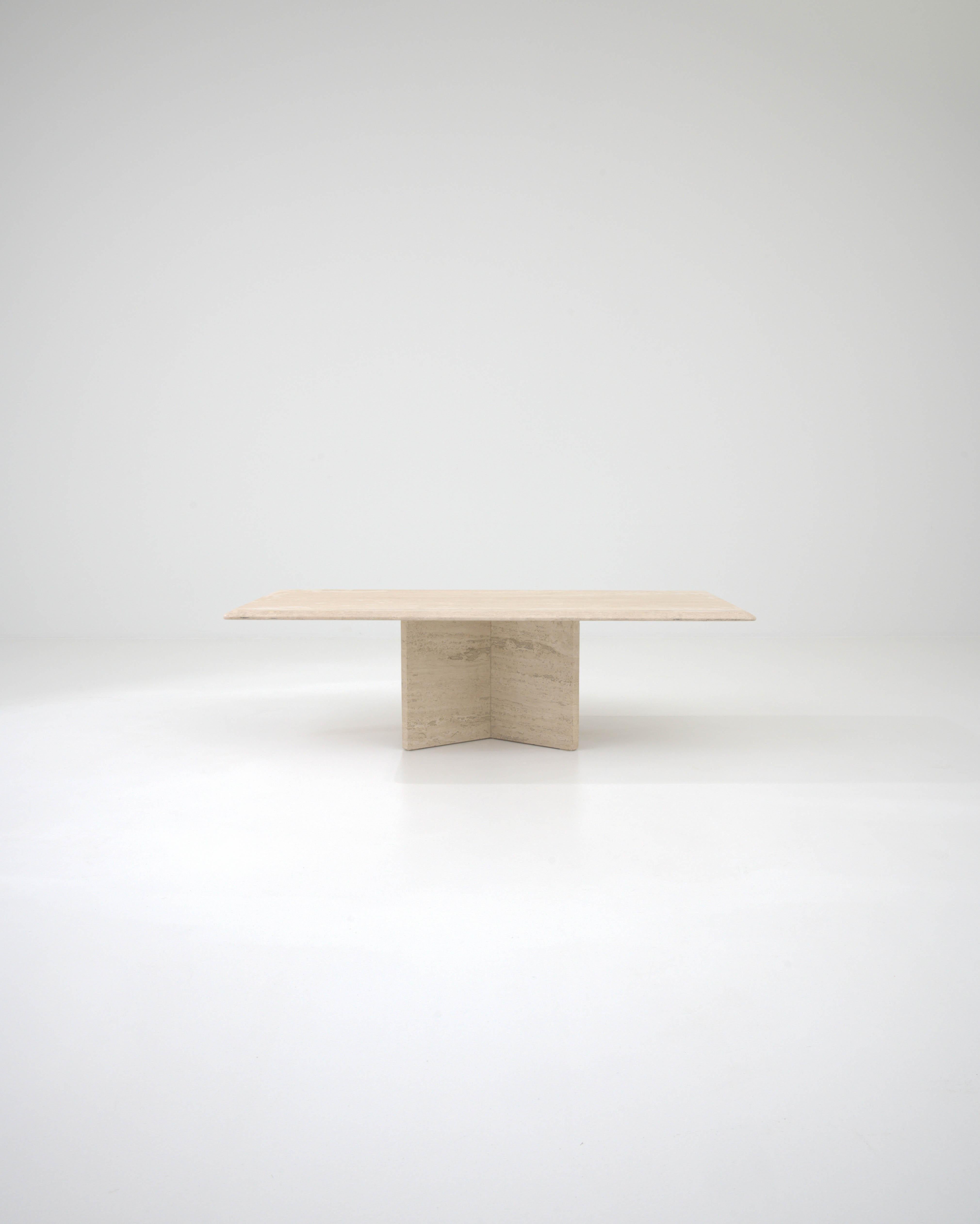 This sculptural table, crafted from cream colored marble in 20th century Italy, features a square slab as its tabletop, elegantly elevated on stone blocks. These blocks are artfully assembled like an open book and secured with metal rings, resulting