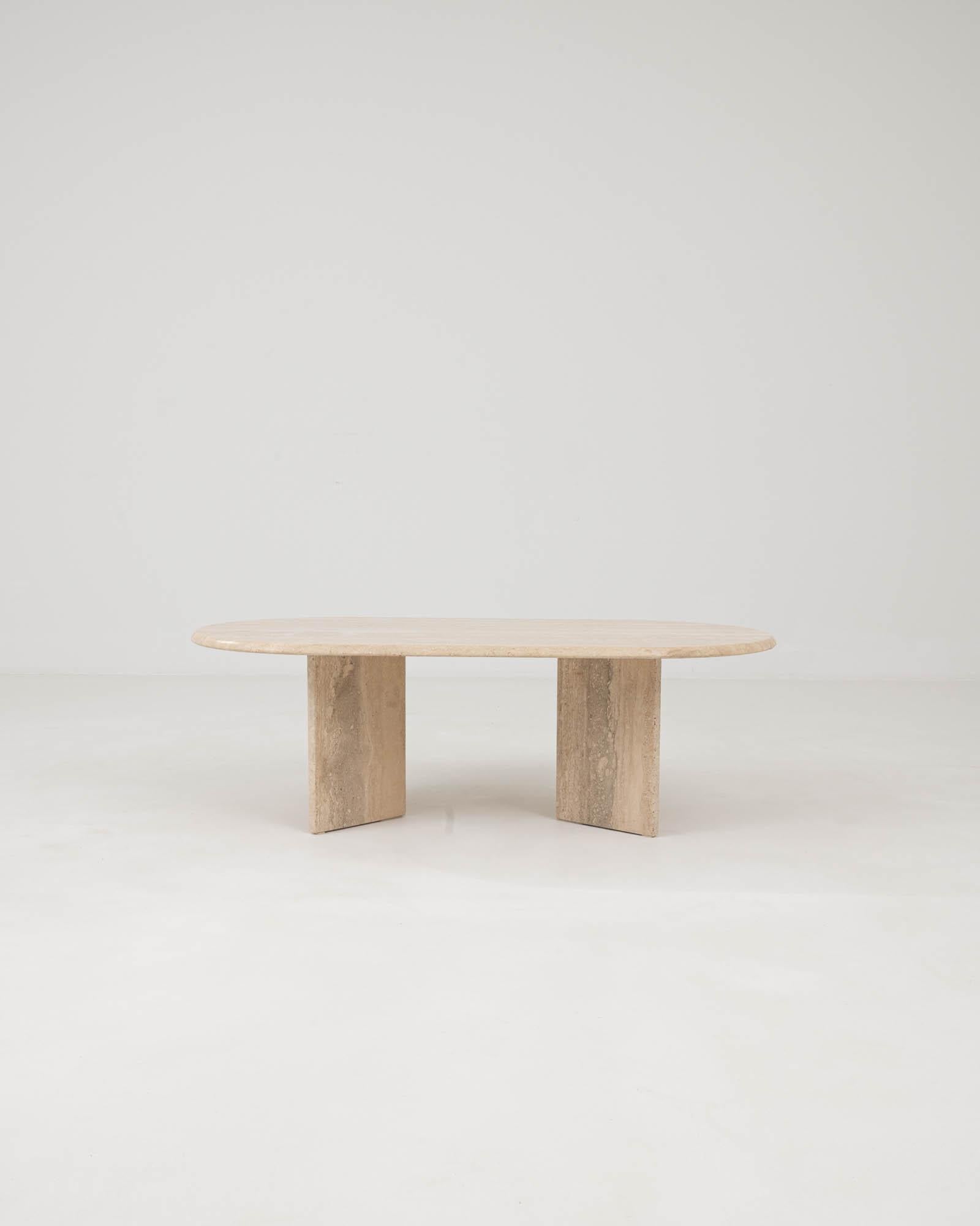 The formal simplicity and rich materiality of this travertine marble coffee table create an impression of minimalist elegance. Made in Italy in the 1970s, a rectangular table top gently rests on opposing low rectangles of stone. The warm neutral