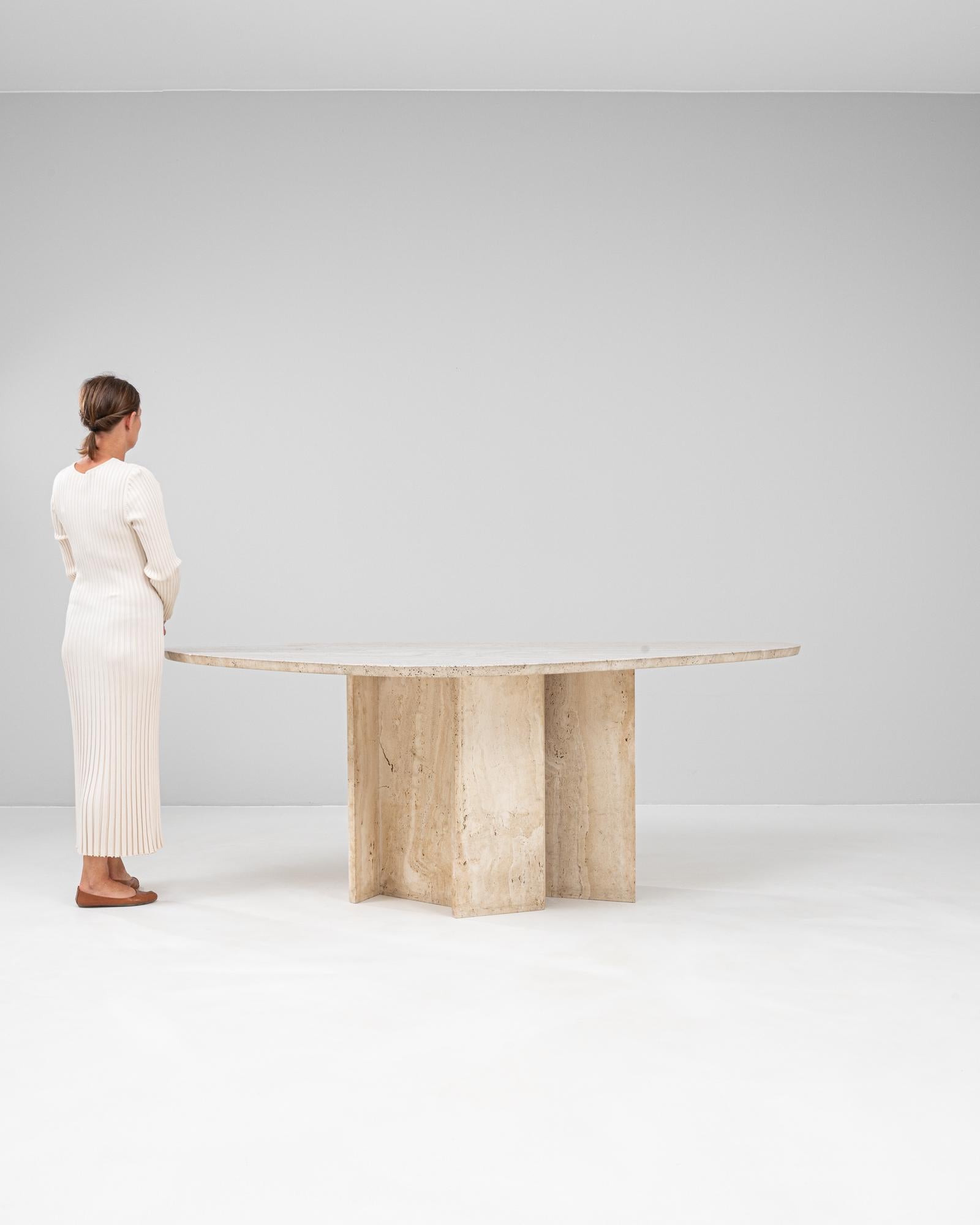 Cette table de salle à manger sculpturale du designer belge Willy Ballez date du XXe siècle et est entièrement fabriquée en marbre travertin. La base architecturale audacieuse comporte quatre panneaux entrecroisés qui forment un support robuste en