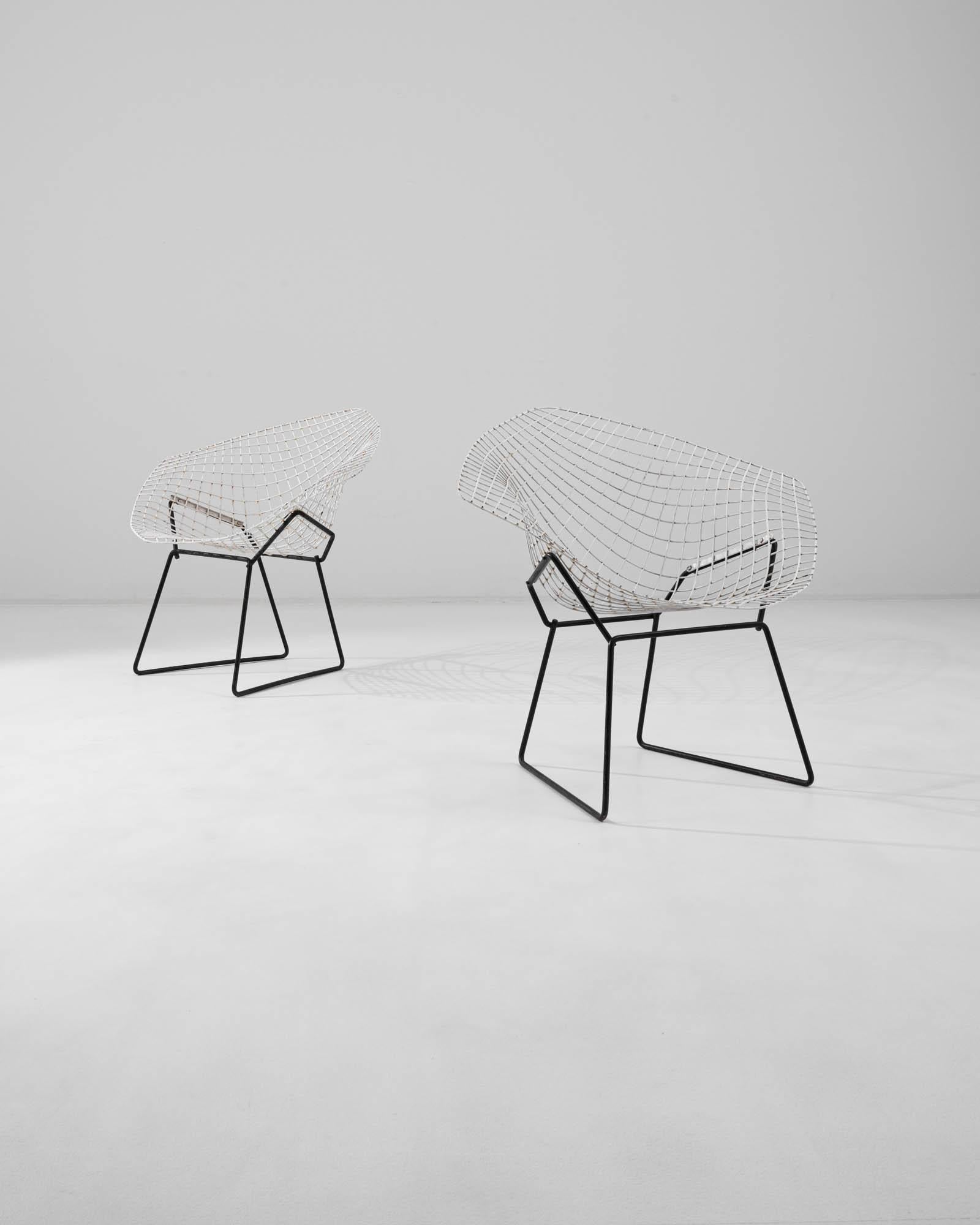 A pair of 20th century Italian metal chairs created by Harry Bertoia. Referred to as ‘diamond chairs,’ these classic mid-century chairs exude a spectacular sculptural sensibility and ergonomic harmony. The flowing metal grid that composes the seat,