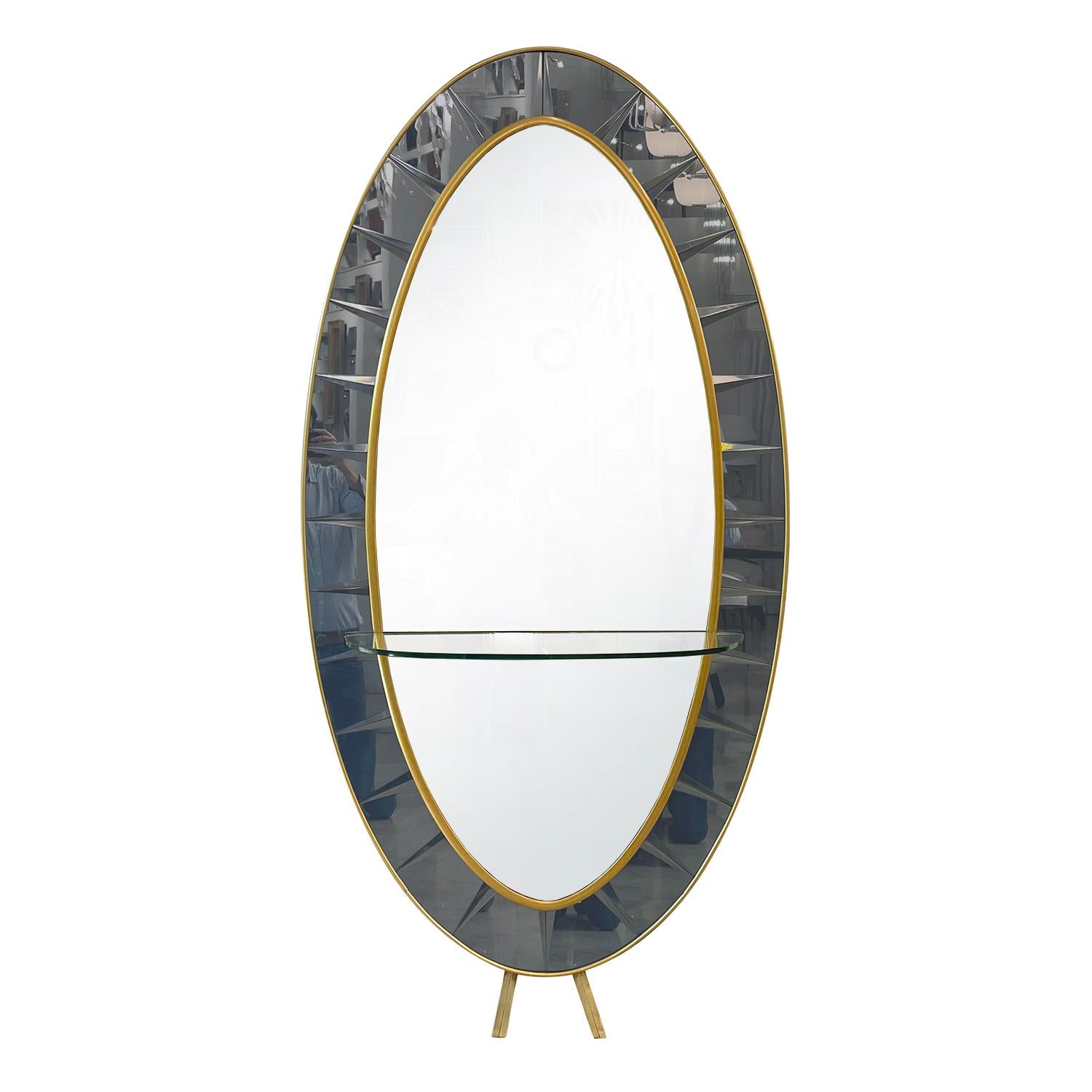 An oval, vintage Mid-Century modern Italian floor mirror made of hand blown cut crystal glass with its original mirrored glass, produced by Cristal Art in good condition. The wall décor piece is composed with a thick clear glass shelf,