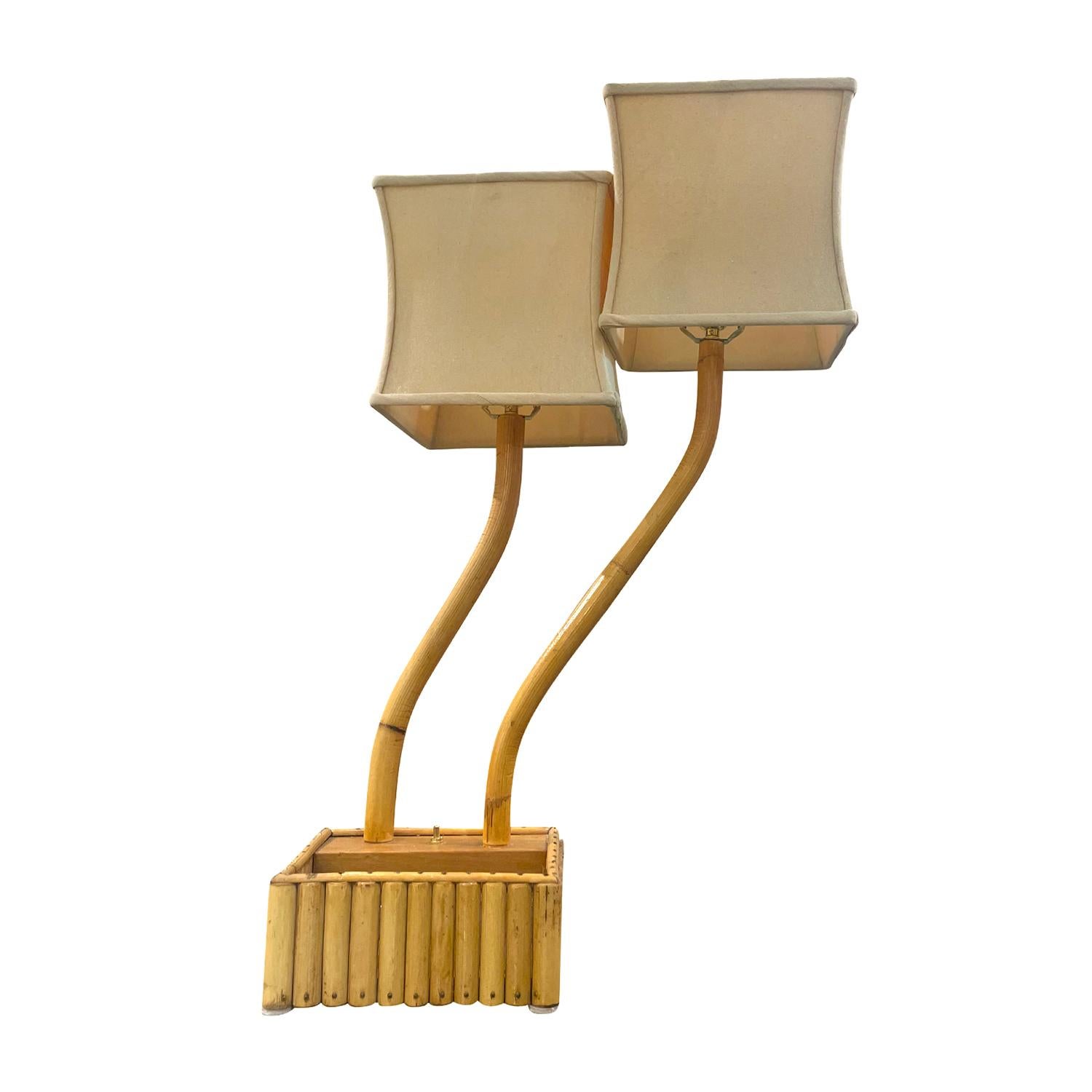 A vintage Mid-Century modern Italian double arm table lamp with a light-brown adjustable rectangular shade, made of hand crafted bamboo in good condition. Each of the detailed light is composed with an arched stem supported by a wooden base which is