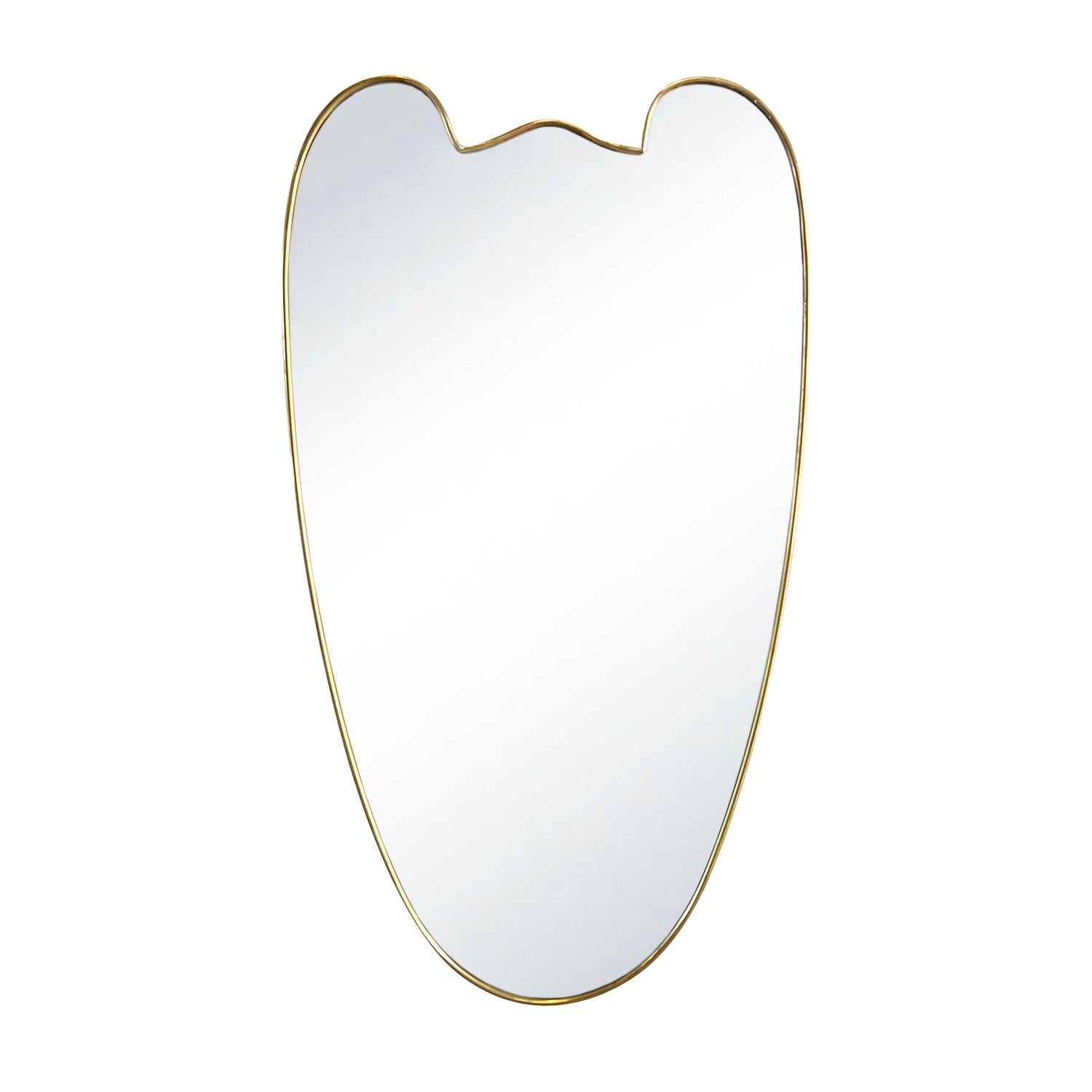 An oval, sculptural vintage Mid-Century modern Italian wall mirror made of hand crafted polished brass in good condition. The modernist mirror is consisting its original mirrored glass. Wear consistent with age and use. Circa 1950 - 1960, Italy.
