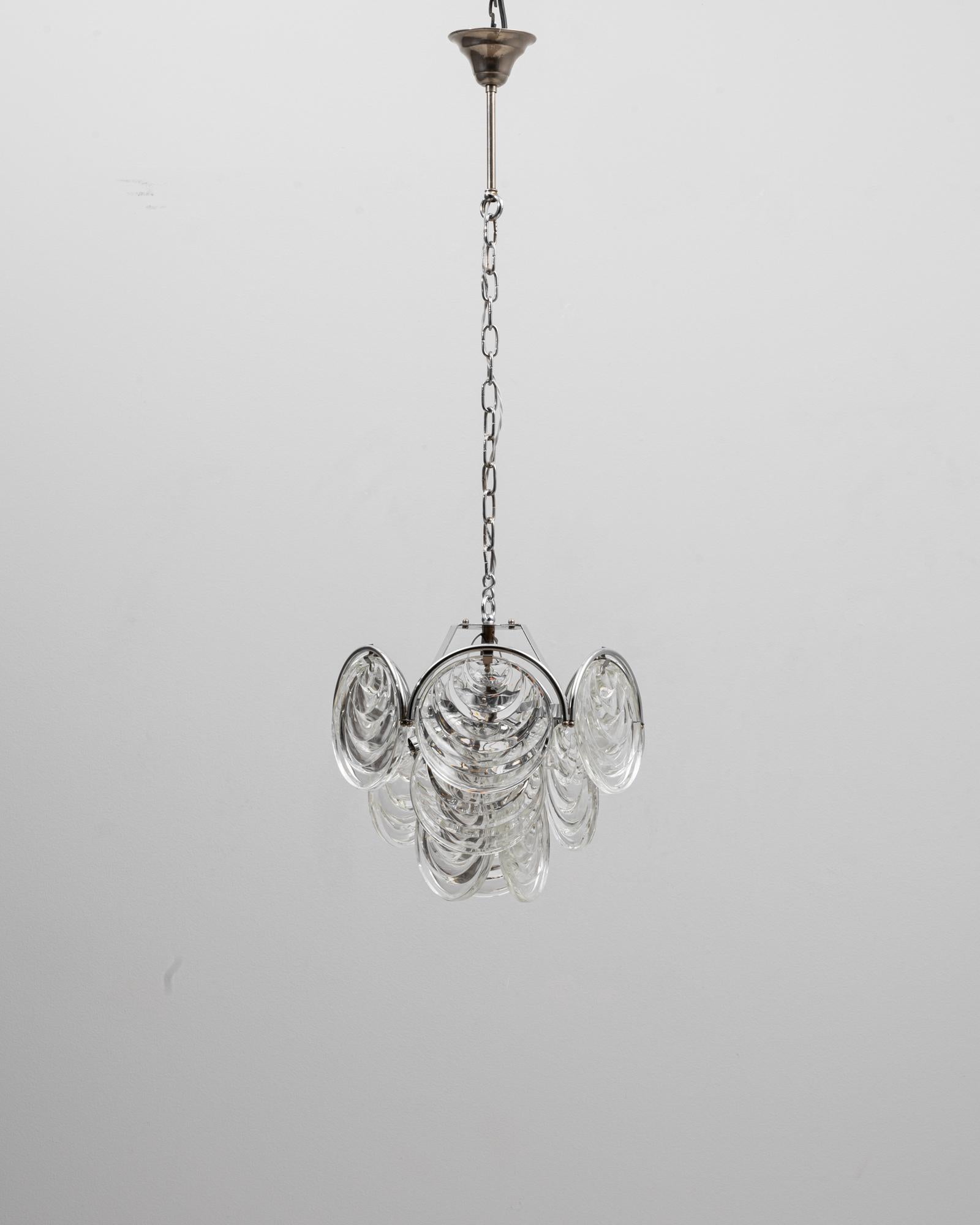 Questo lampadario in stile italiano di Murano del XX secolo presenta una sorprendente composizione di dischi di vetro soffiato a mano sospesi da una struttura in cromo lucido. I dischi di vetro trasparente, realizzati nel tradizionale stile di