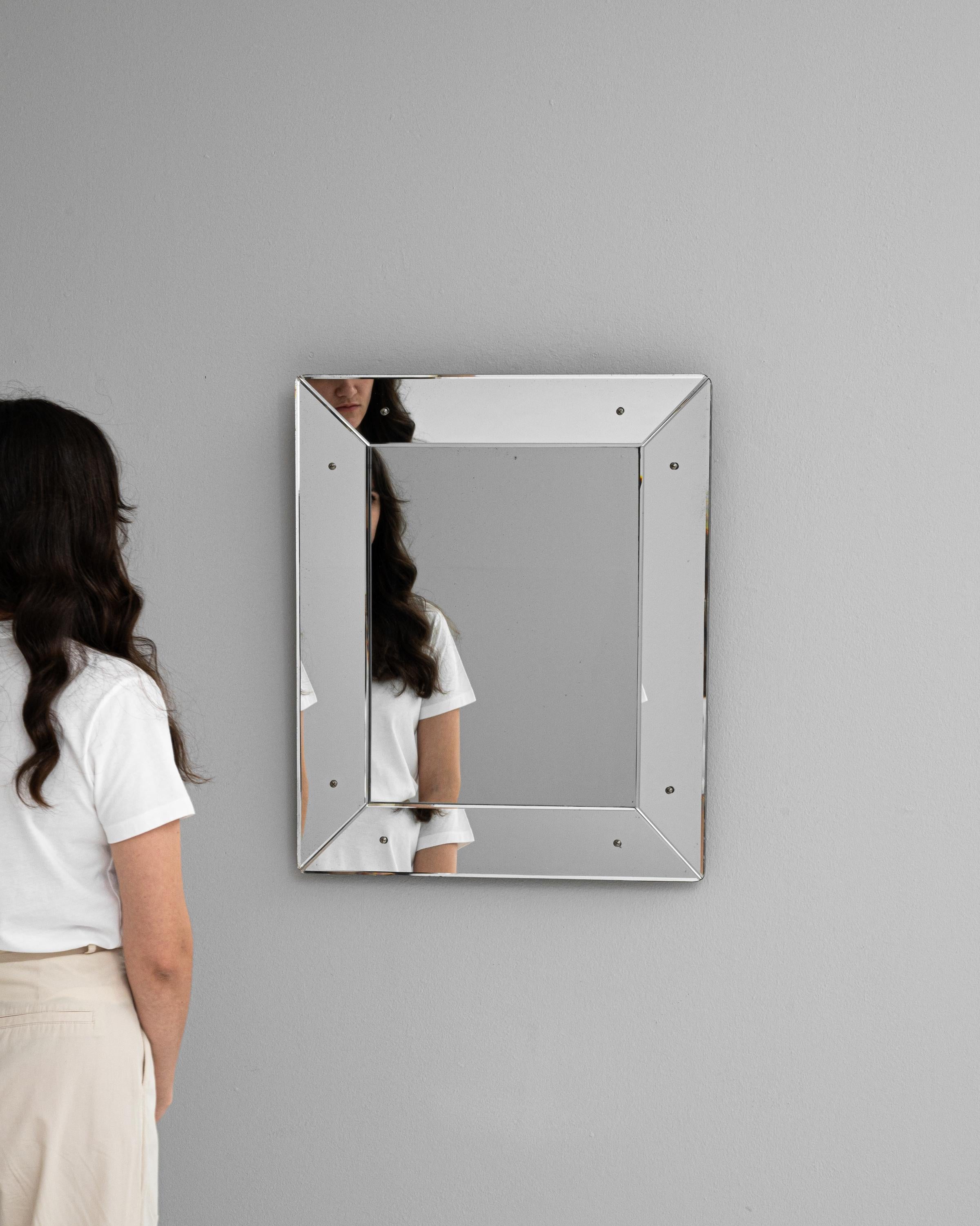 This 20th Century Italian Mirror showcases the sleek lines and understated elegance characteristic of Italian design. The frame, constructed with a metallic finish, lends a modern and minimalist aesthetic, while the visible screws add an industrial