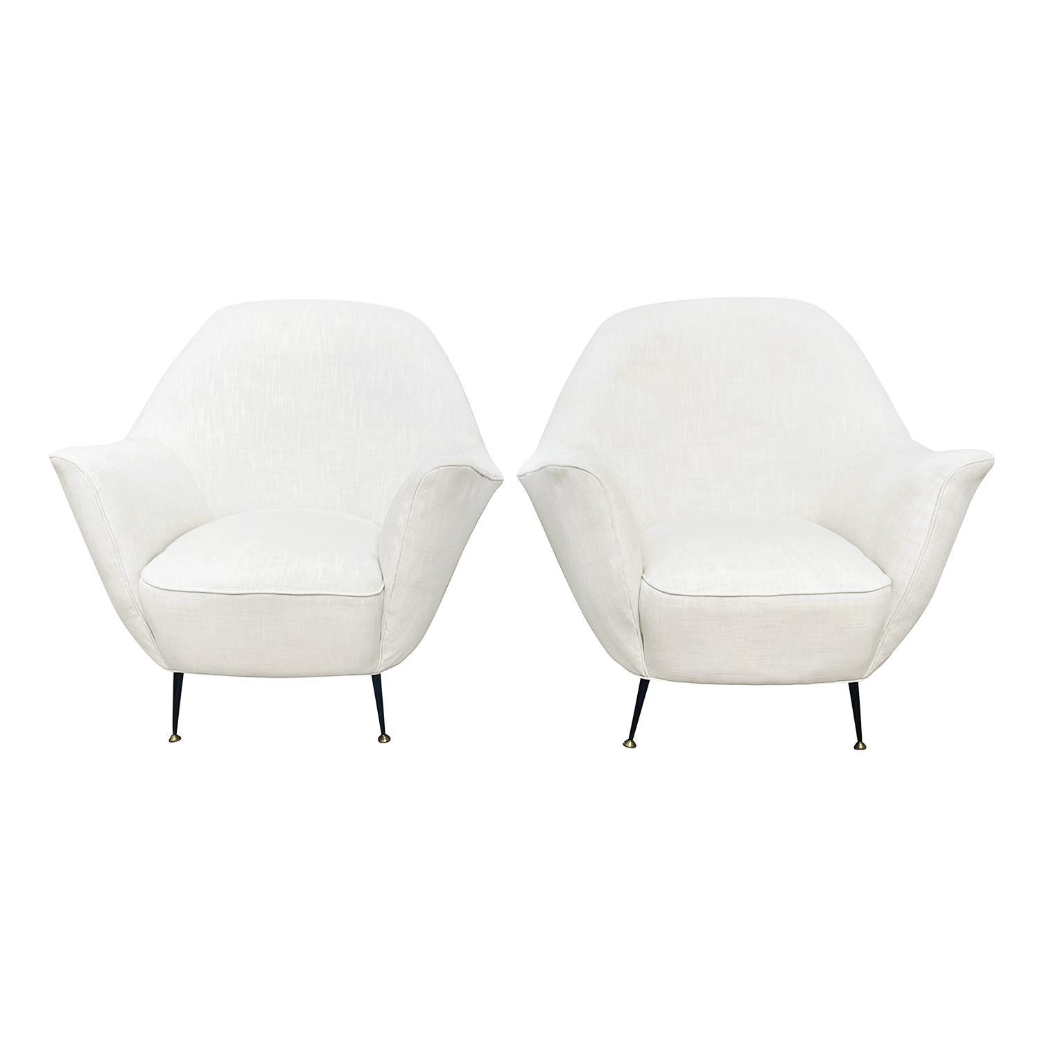A 20th Century, vintage Mid-Century modern Italian pair of club chairs in the style of Ico Parisi, in good condition. The seat backrest is slightly leaned to the back with outstretched arms, standing of four slanted iron legs. Newly upholstered in a
