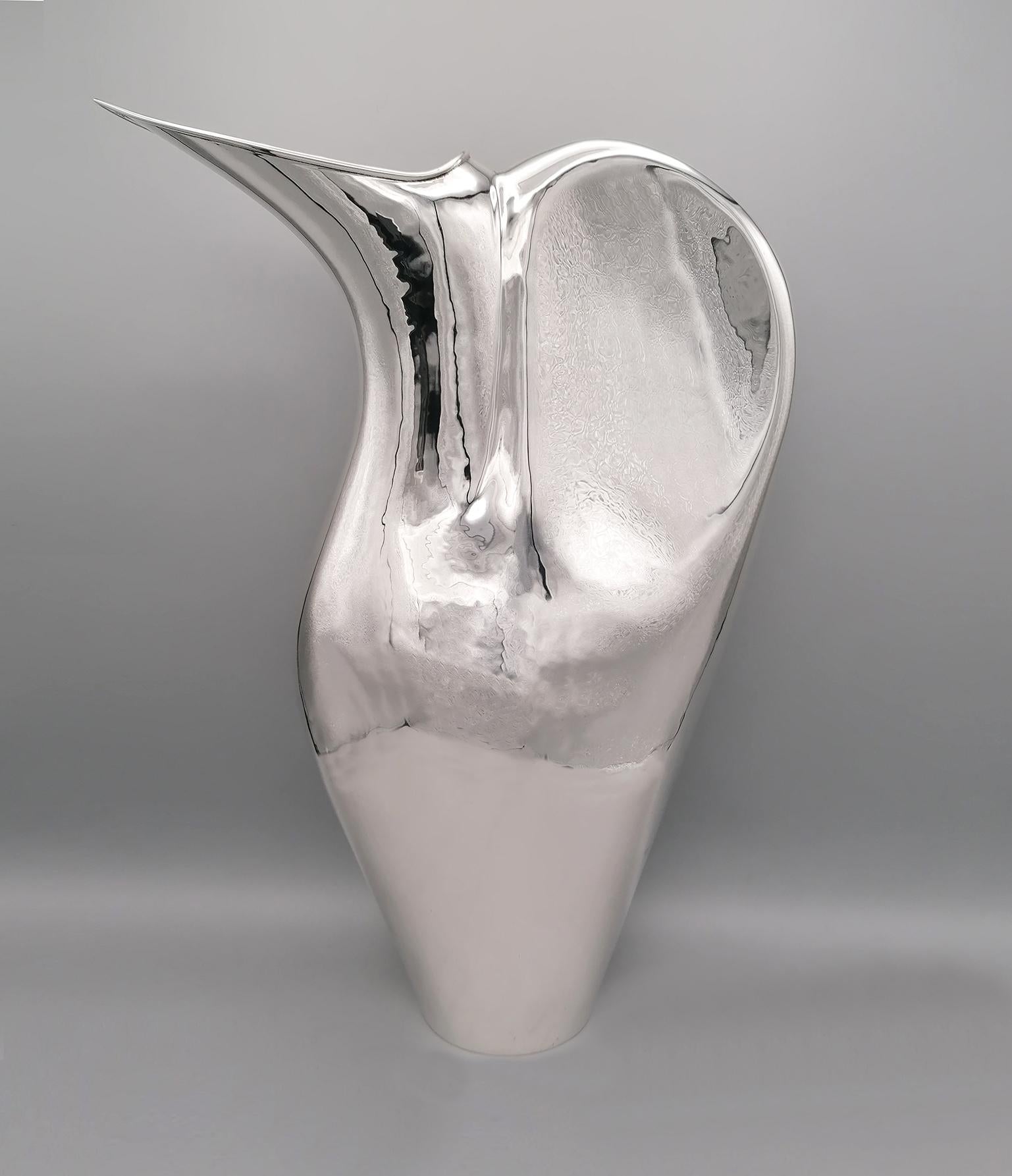 Modern jug-vase. Made of solid silver plate fully molded by hand.
The jug is inspired by the shape of the penguin.

Solid silver 800°°/°°°. 1,210 grams.