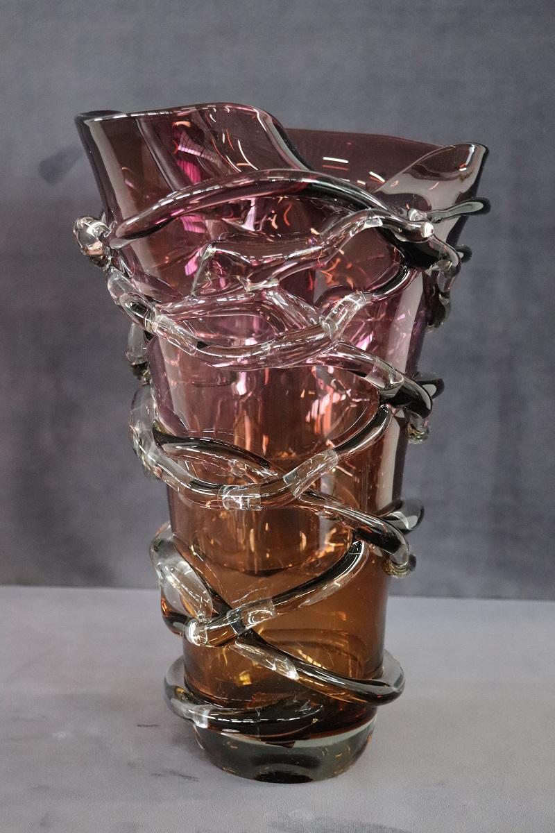 Raffinato vaso italiano di grandi dimensioni in vetro artistico di Murano, anni '80. Questo vaso è caratterizzato da una particolare forma del design. Il vaso è di alta qualità artistica in vetro soffiato. Il colore del bicchiere sfuma dall'ambra in
