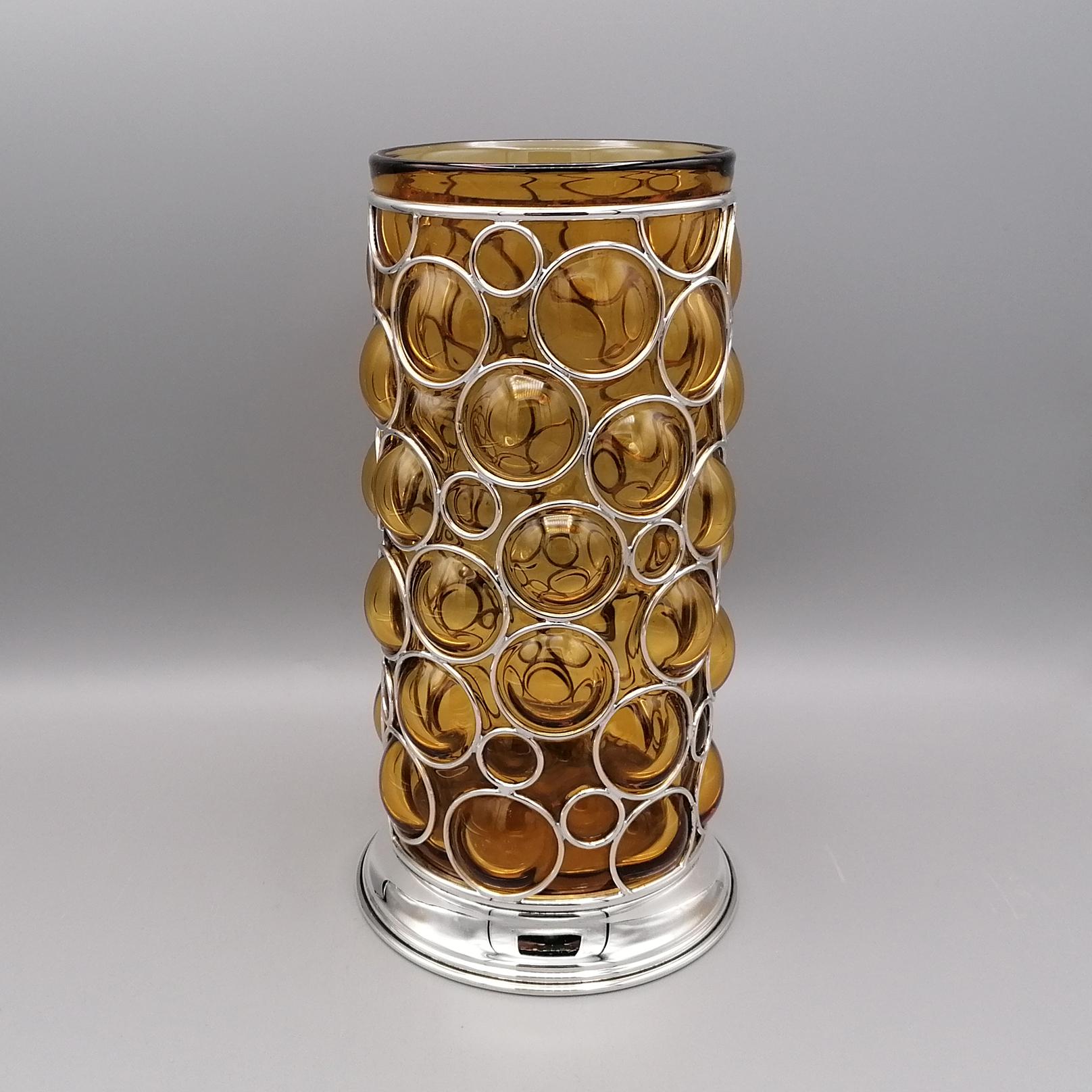 Murano glass vase with base and cage in solid sterling silver.
The amber-colored vase was made in Murano, Venice - Italy and subsequently a renaissance-style ring-shaped sterling silver grid was mounted to embellish the work. 
The vase was then