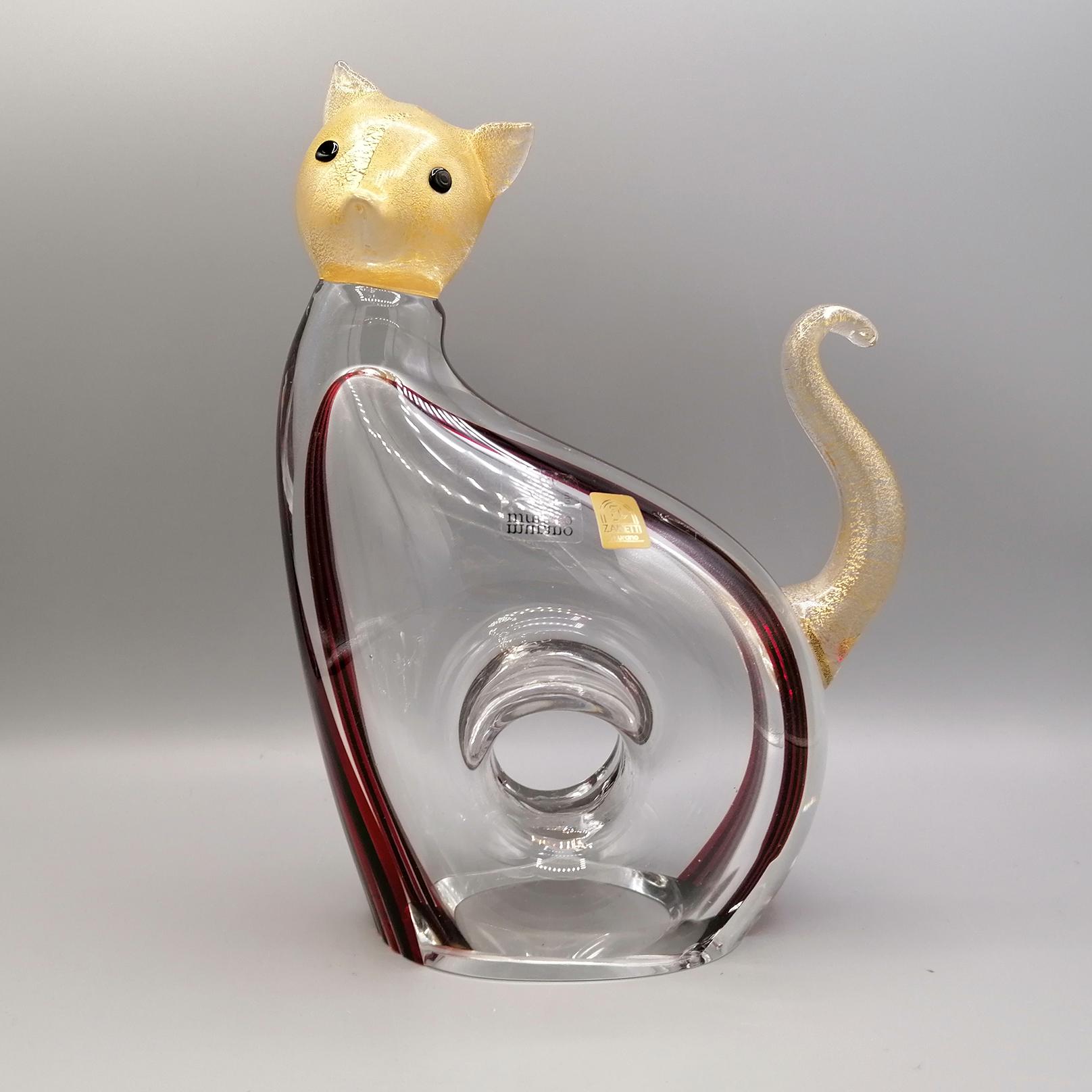Stylized cat in Murano glass produced in Murano.
Made of transparent glass and embellished with black and amaranth white streaks that make this ornament elegant and in the same way ... trendy
Entirely made of mouth-blown glass, the cat’s body is
