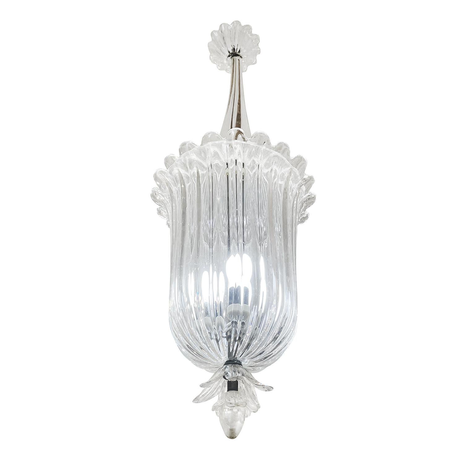 A vintage Mid-Century Modern Italian pendant made of hand blown clear Murano glass, designed and produced by Archimede Seguso and Seguso Vetri D’Arte, in good condition. The detailed round flower vase chandelier is supported by a brass beam,