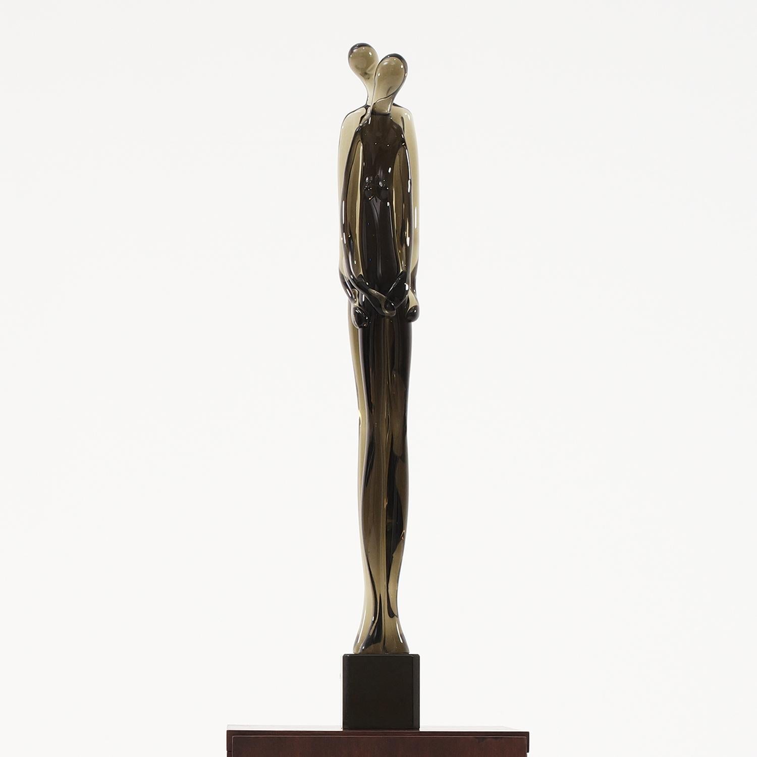 Grande scultura vintage Mid-Century Modern di una coppia abbracciata, in vetro di Murano soffiato a mano e affumicato, disegnata da Pino Signoretto, di colore nero-viola e in buone condizioni. Il pezzo decorativo dettagliato rappresenta una donna e