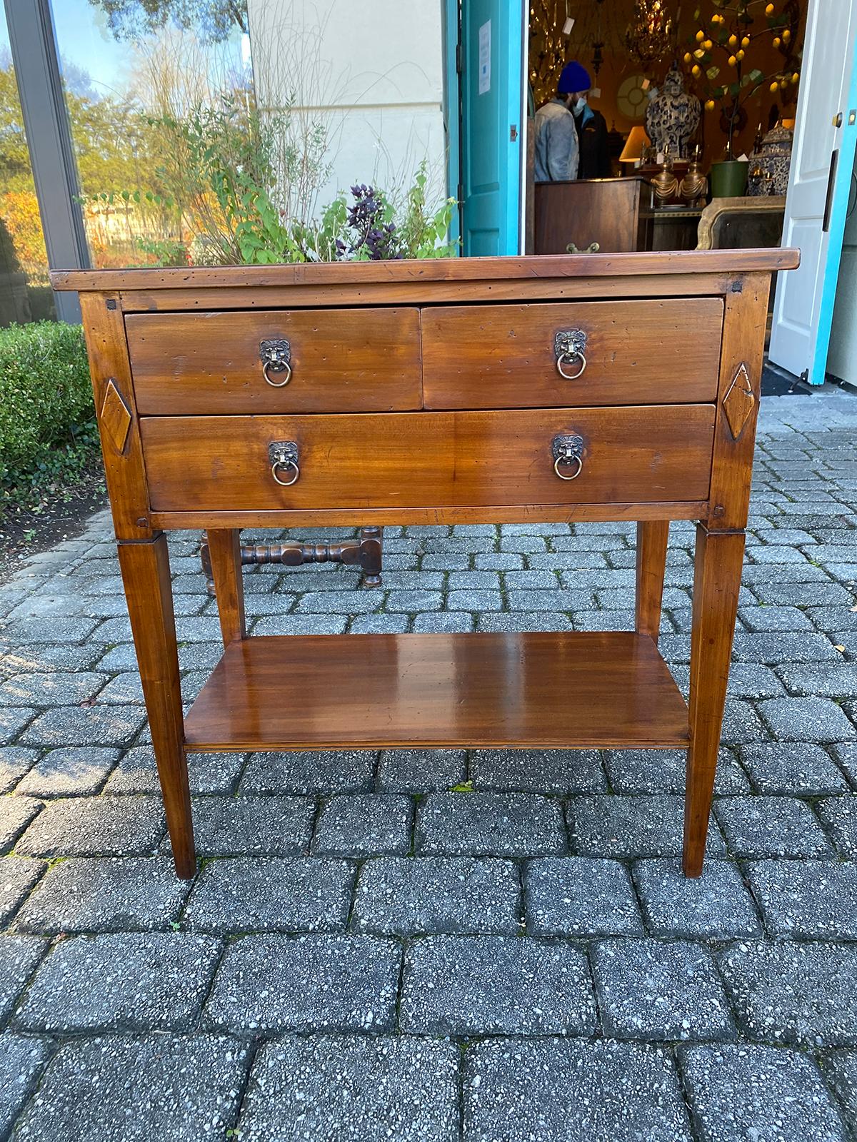 20th century Italian neoclassical side table with three drawers and lion pulls.
