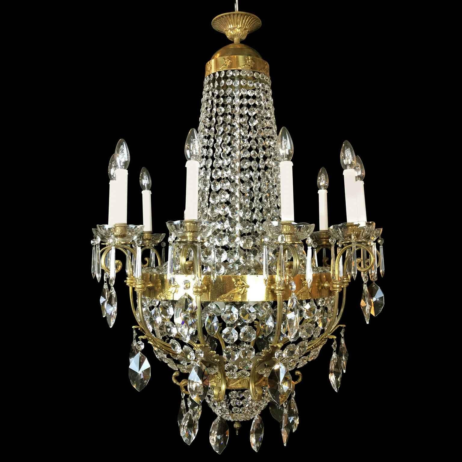 A 20th century Italian seventeen-light crystal chandelier richly decorated with waterfall crystal festoons and pendants, realized with a Neoclassical style ormolu frame decorated by casted Roman Matron figures seated on dormeuse with palmetta shaped