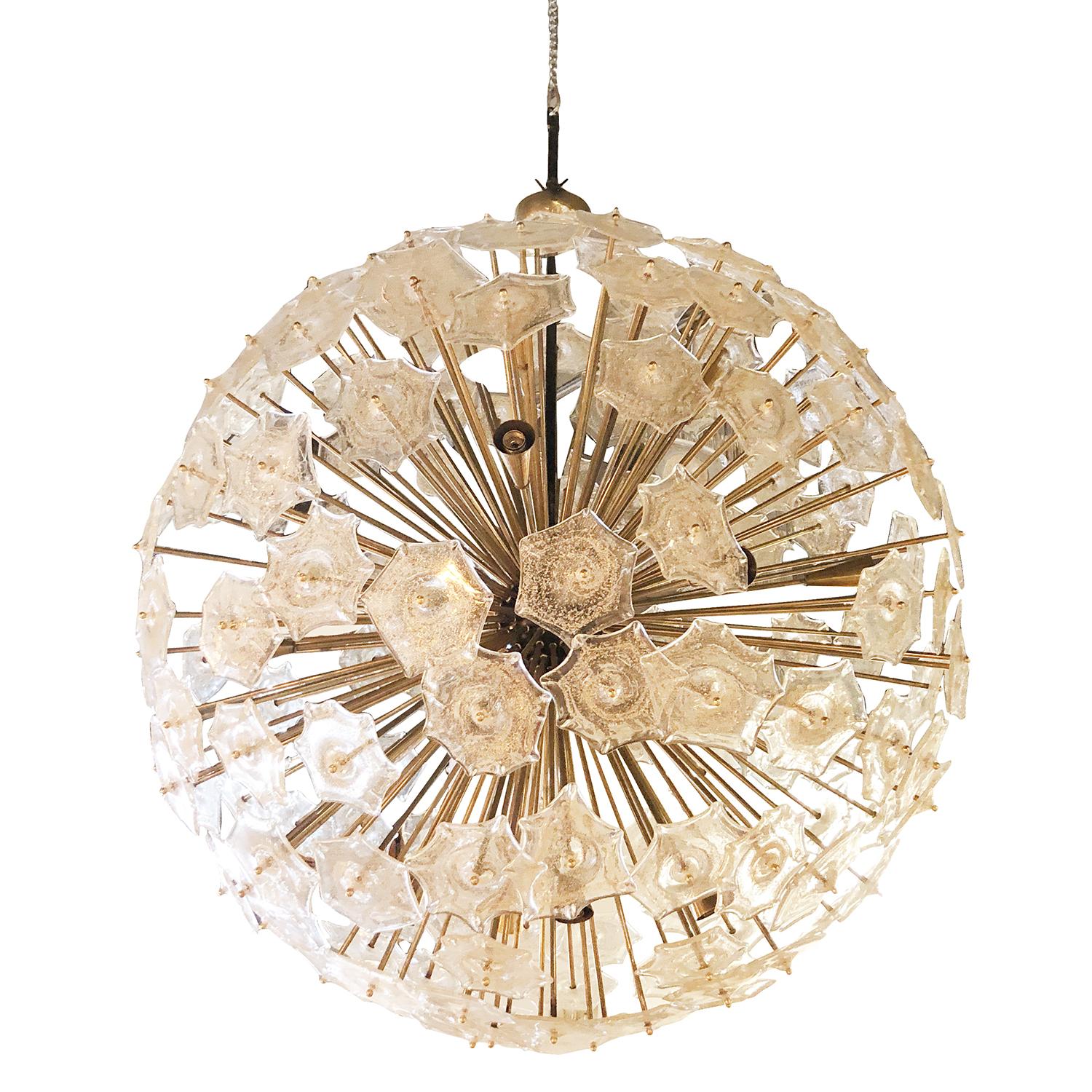 A very large Mid-Century Modern Italian chandelier of round shape, designed with octagonal heavy Murano glass elements, with brass finial finish and structure. The vintage ceiling mount pendant has twelve light sockets, stunning design element for
