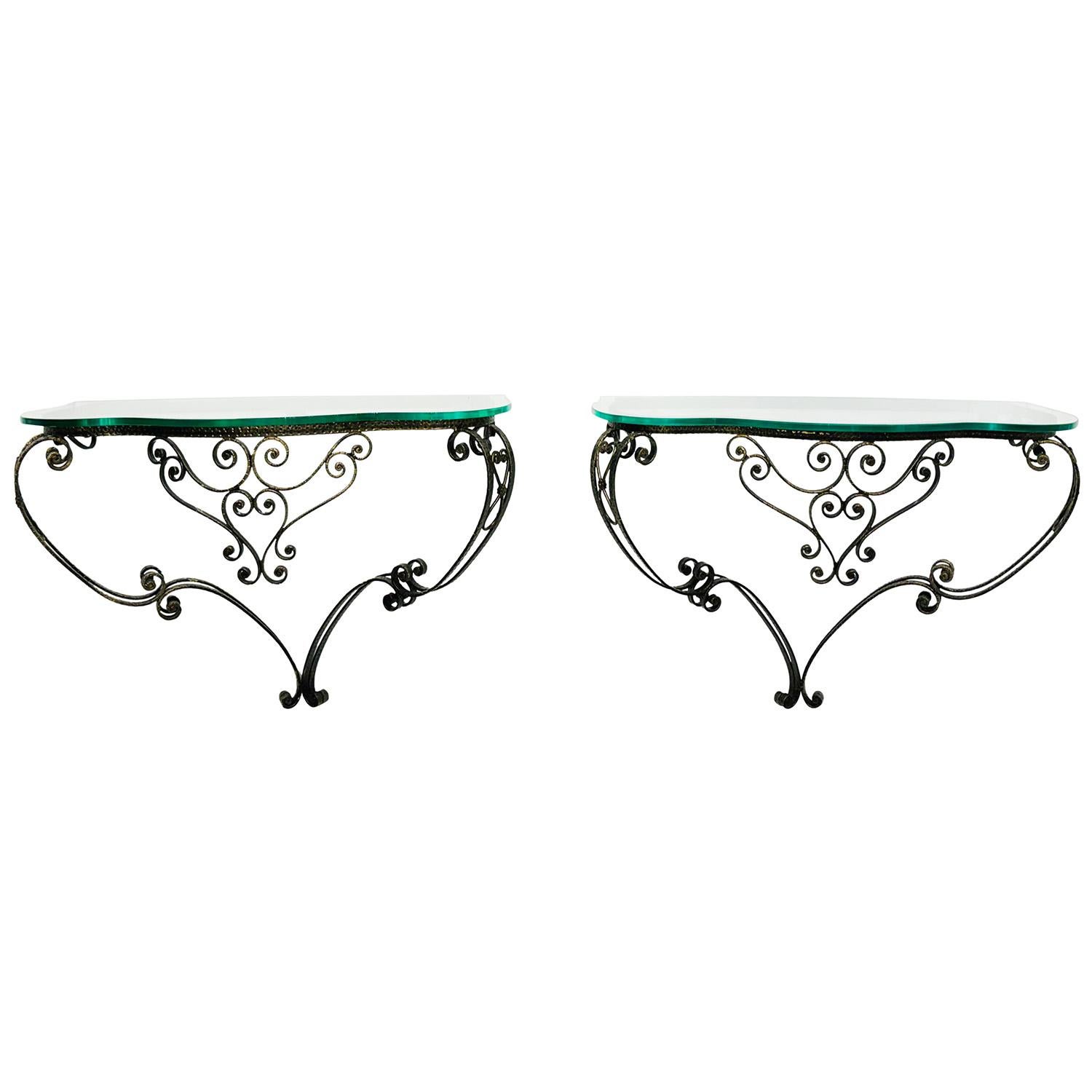 Pareja de consolas italianas vintage de mediados de siglo, de metal dorado artesanal, diseñadas por Piere Luigi Colli, en buen estado. Las detalladas mesas en forma de demi-luna se montan en la pared, particularizadas con un tablero de cristal