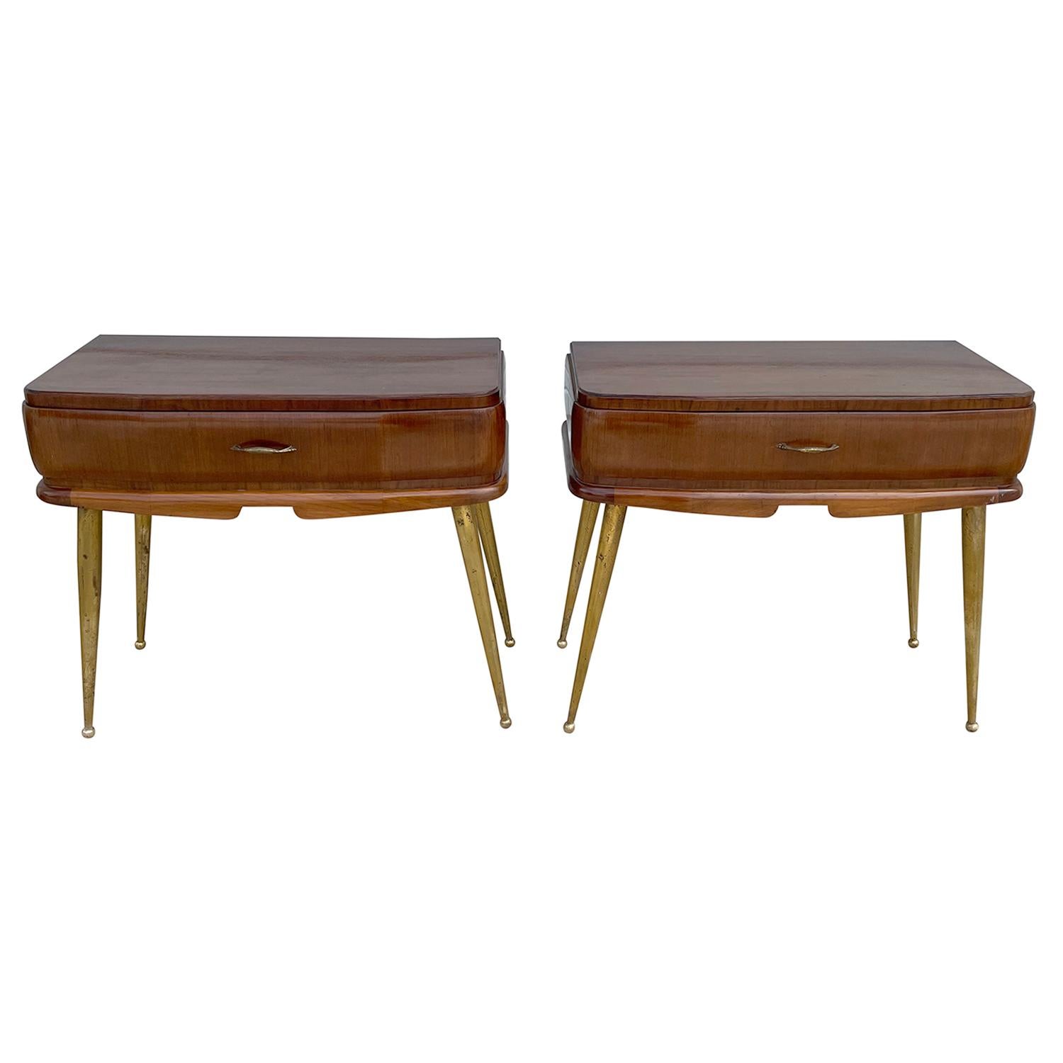 A dark-brown, vintage Mid-Century Modern Italian pair of nightstands, bedside tables made of hand crafted polished Mahogany with one-drawer, enhanced by detailed brass handles, supported four curved legs, in good condition. Wear consistent with age
