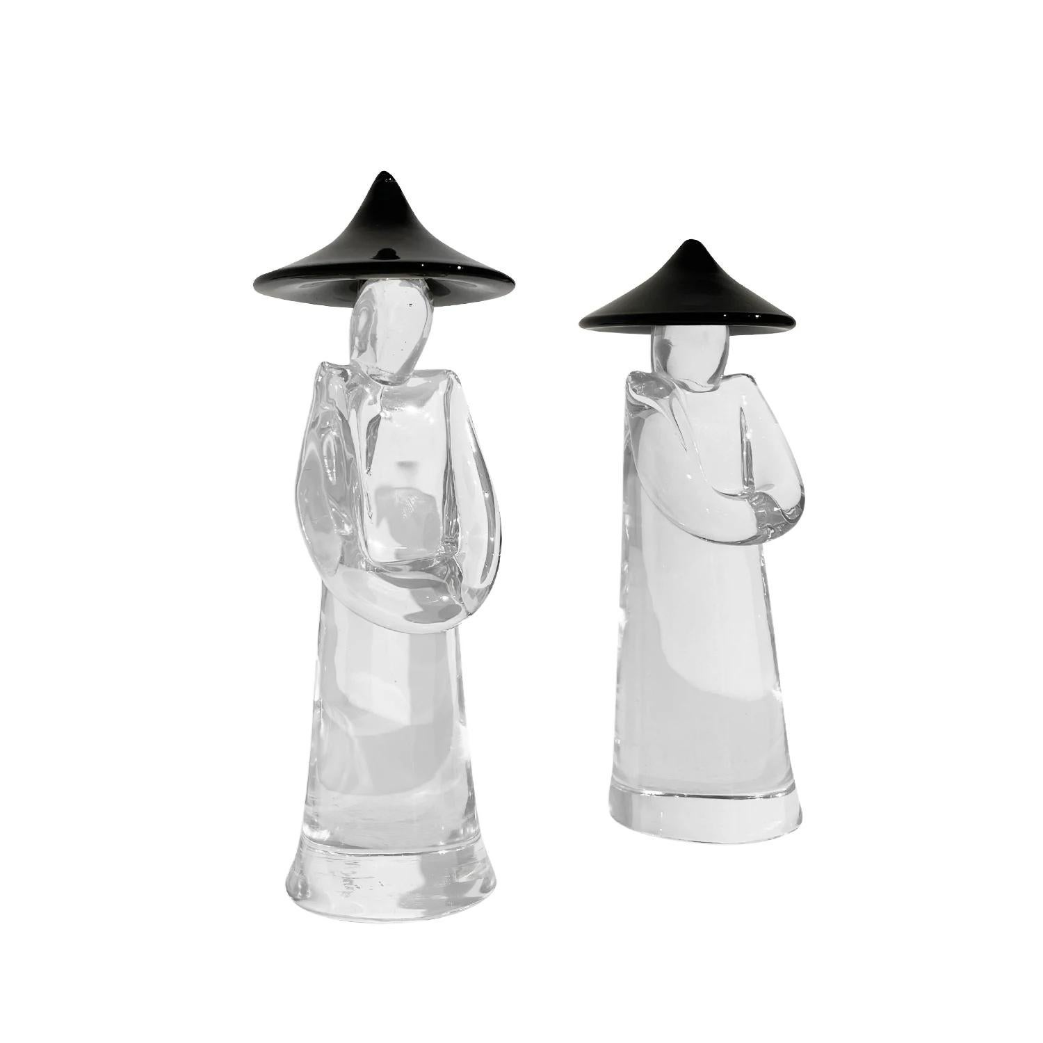 A vintage Mid-Century Modern Italian pair of Japanese farmers with a large black hat made of hand blown clear Murano glass, designed and produced by Pino Signoretto in good condition. The detailed décor pieces represent a woman and man. Signed at