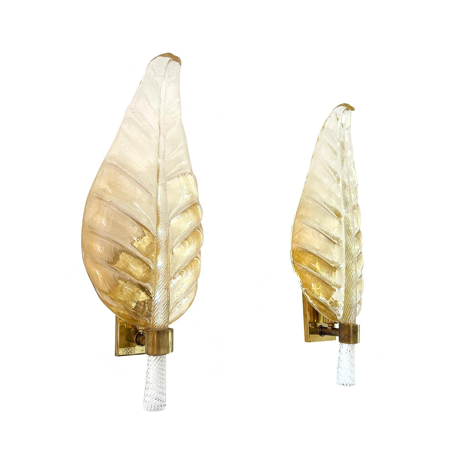 A smoked gold, vintage Mid-Century Modern Italian pair of wall sconces made of hand blown Murano glass Oro Sommerso with a polished brass stripped ring, supported by a rectangular brass structure, imitating a large leaf. Each of the light fixtures