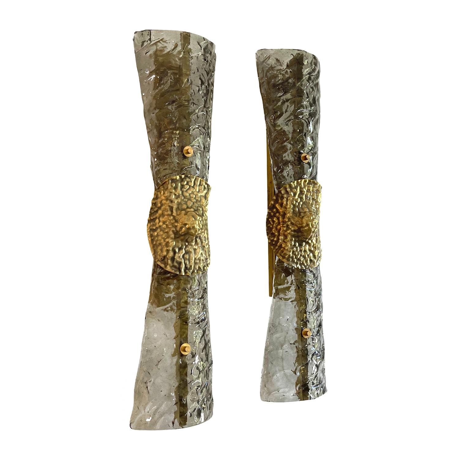 A smoked, light-grey, vintage Mid-Century Modern Italian pair of wall lights made of hand blown Murano glass Sommerso, supported by a brass structure, imitating a ribbon. Each of wall sconces features a two light socket, in good condition. The wires