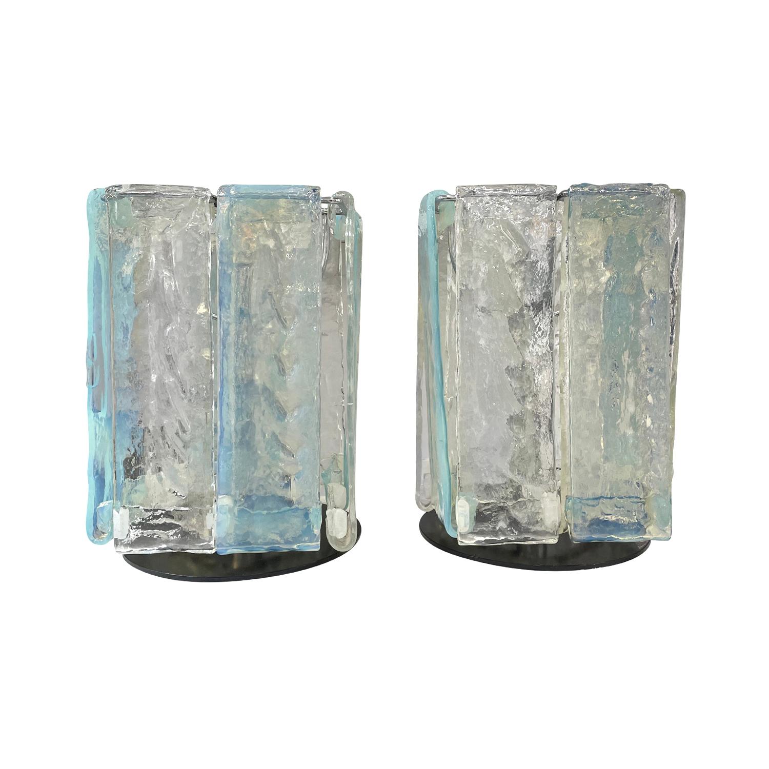 A vintage Mid-Century modern Italian pair of table lamps made of hand blown colored Murano glass designed and produced most likely by Mazzega, in good condition. Each of the detailed light is composed with eight clear glass and four light-blue long