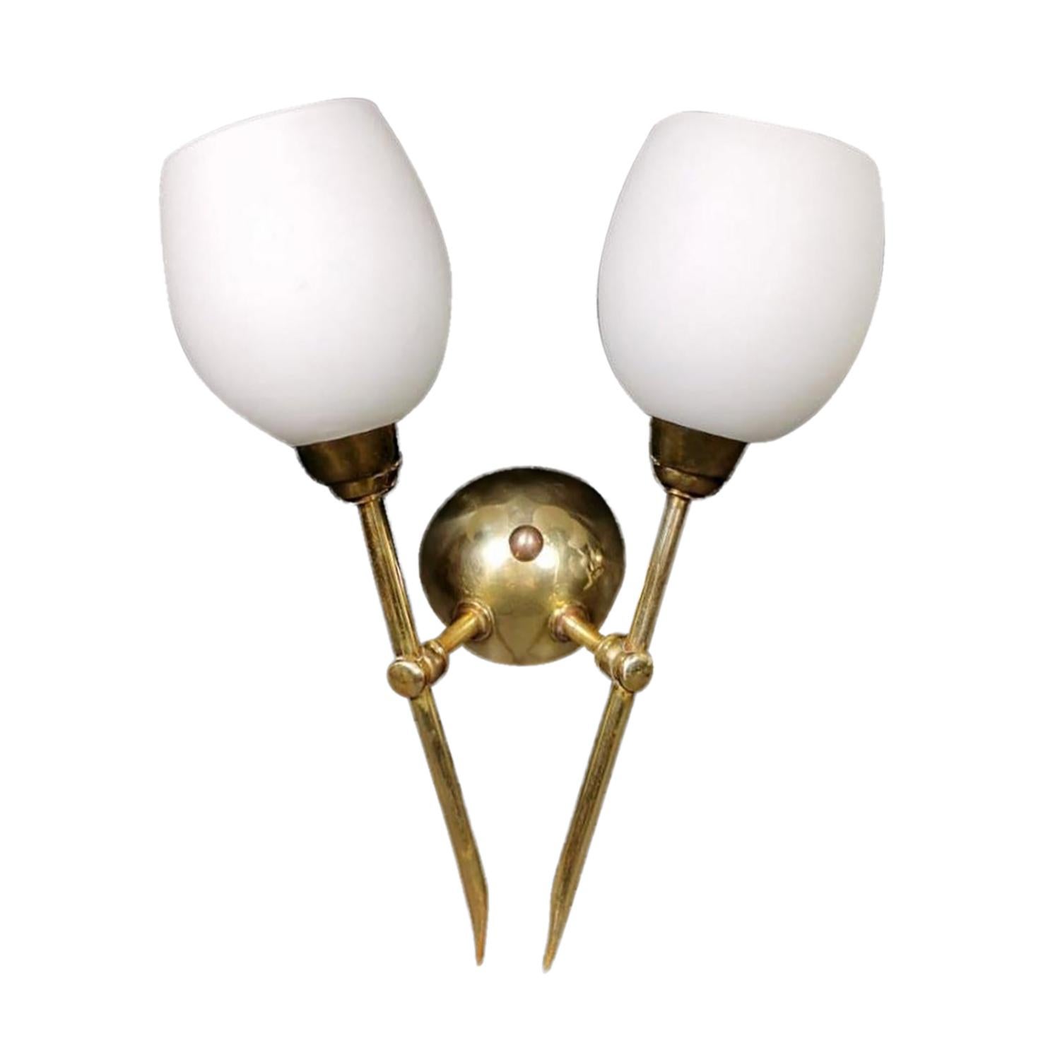 Una piccola coppia vintage di applique italiane del Mid-Century Modern, applique in ottone lucido lavorato a mano e vetro opalino, in buone condizioni. I quattro paralumi in vetro bianco latte imitano un tulipano e ciascuno di essi è dotato di una