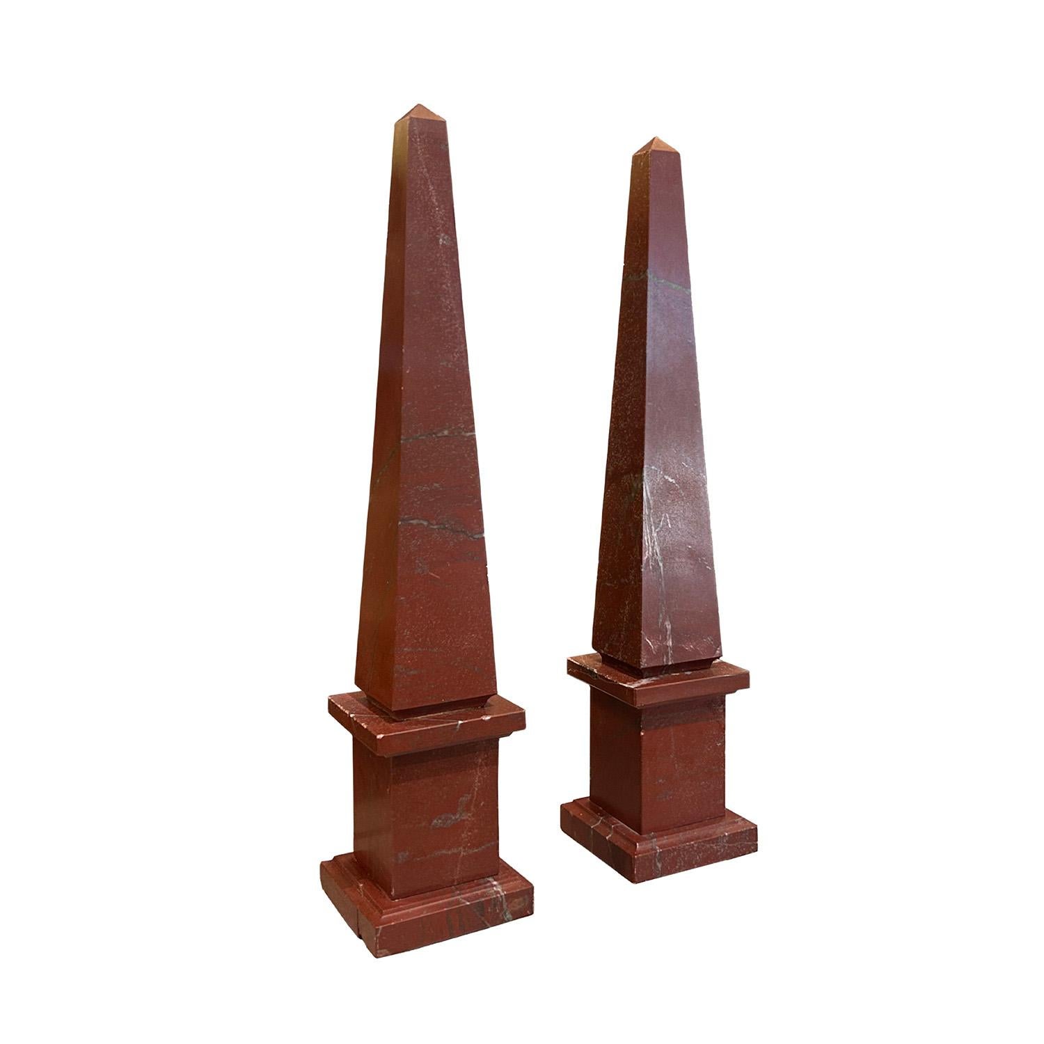Una coppia di piccoli obelischi italiani d'epoca dei primi del Novecento in marmo porfido scolpito a mano, in buone condizioni. I pezzi decorativi dettagliati poggiano su una base quadrata. Leggero scolorimento, crepe dovute all'età. Usura coerente