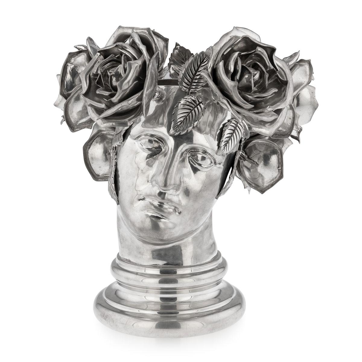 This wine cooler is a rare opportunity to own one of his creations produced in the era of his collaboration with Atena, a pewter manufacturer of the highest level based in Brescia, northern Italy. An inclined female head with a crown of roses and