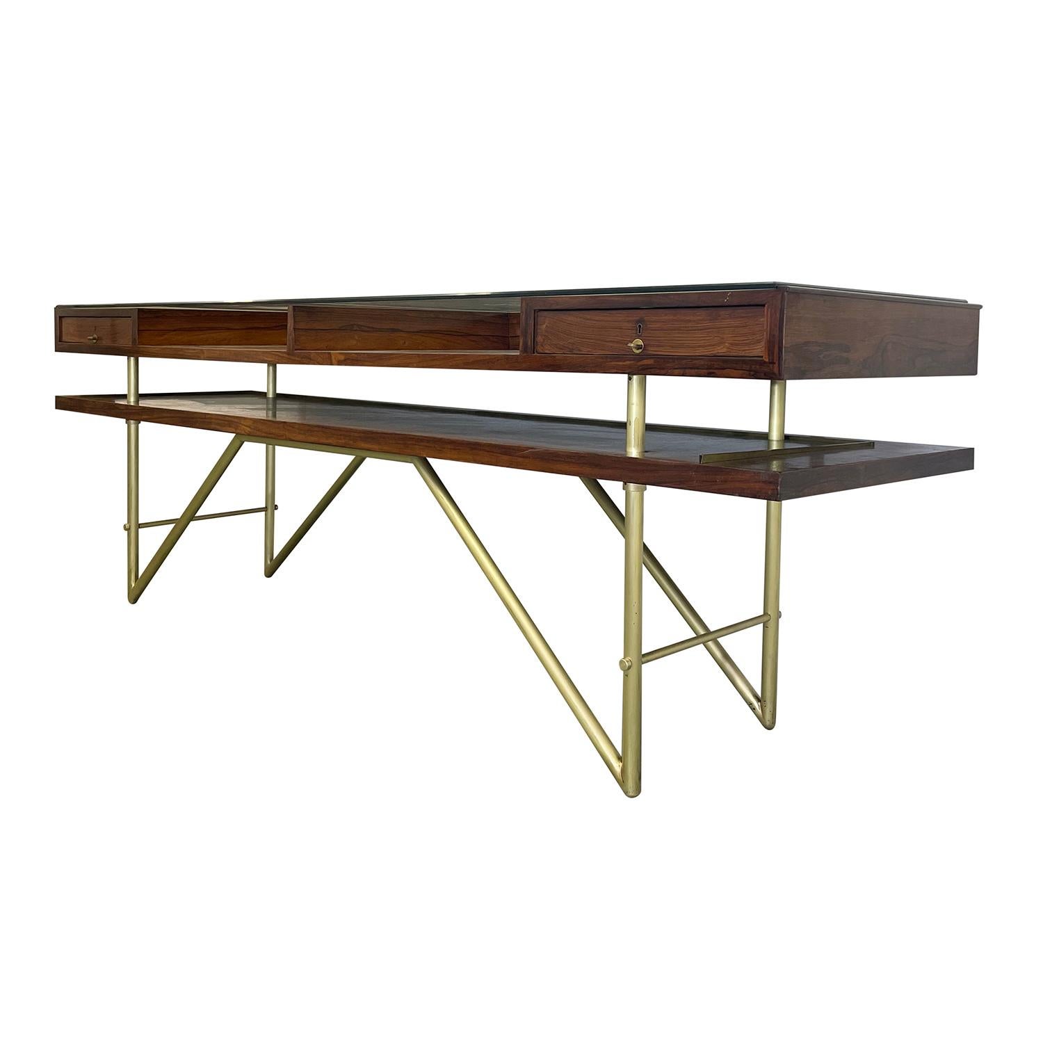 A rectangular, vintage Mid-Century modern Italian sales counter table made of hand crafted polished Rosewood, in good condition. The large buffet serving table is composed with its original clear glass top, a single drawer on each side, and two
