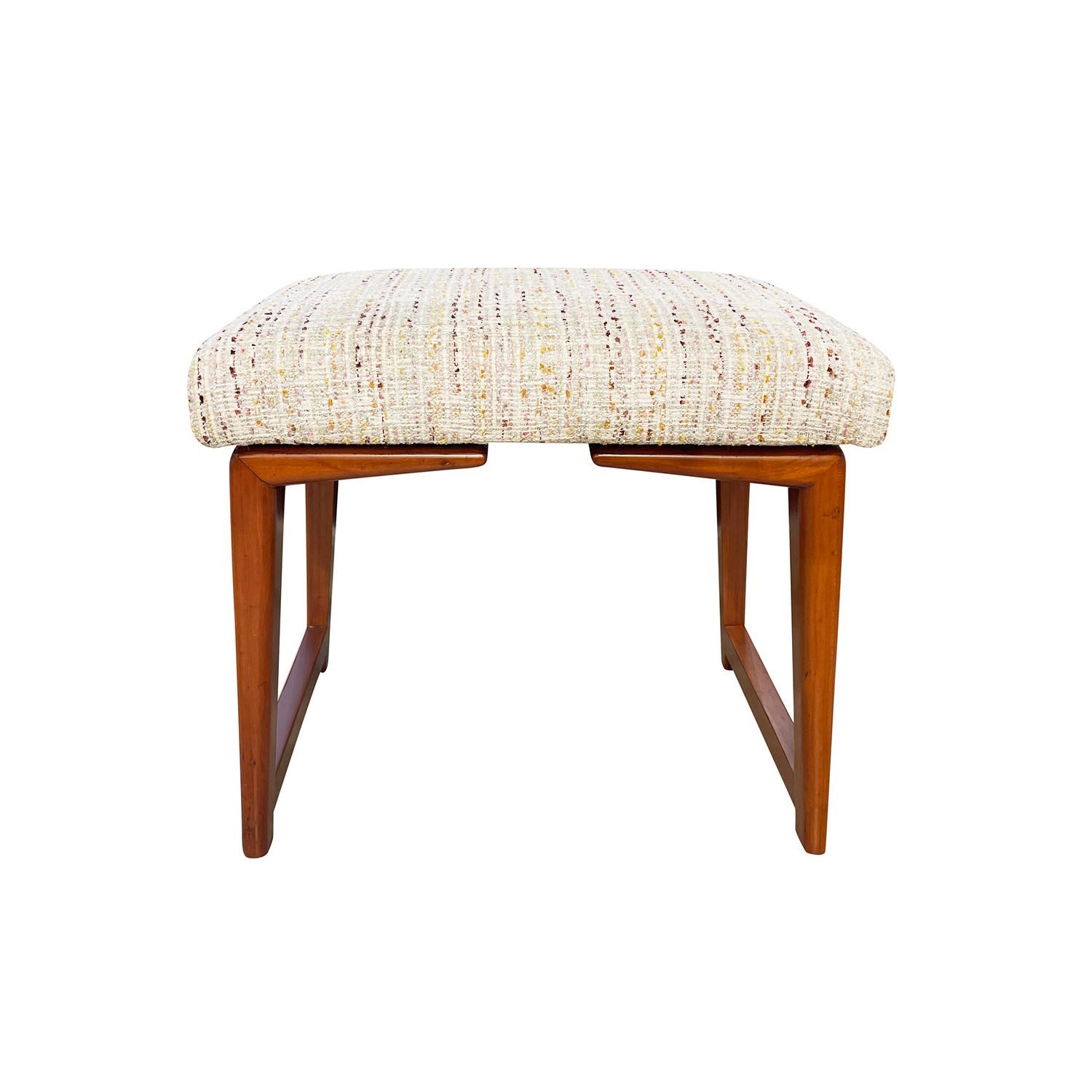 A rectangular, vintage Mid-Century modern Italian piano stool made of hand crafted polished Walnut, in good condition. The detailed ottoman is supported by four arched wooden legs. Newly upholstered in an an oat milk cotton fabric, detailed with
