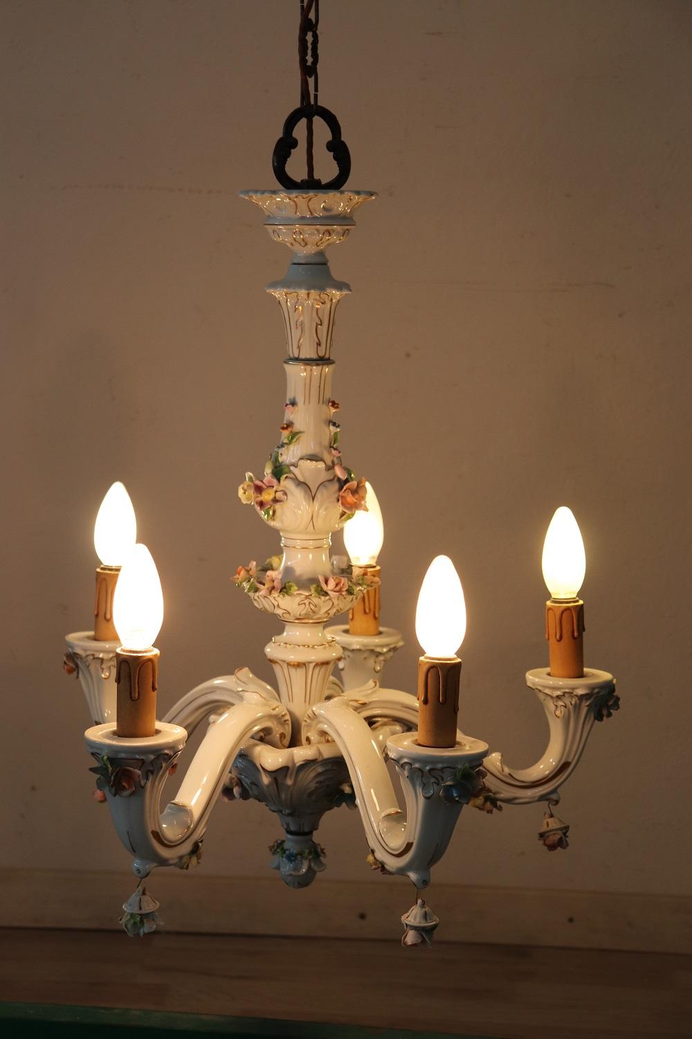 Beautiful and refined Italian chandelier 5-light. This chandelier is a masterpiece of the manufacture of Cpodimonte made entirely of ceramic and hand painted. Many decorative elements make this chandelier unique, many colorful flowers sitting on the