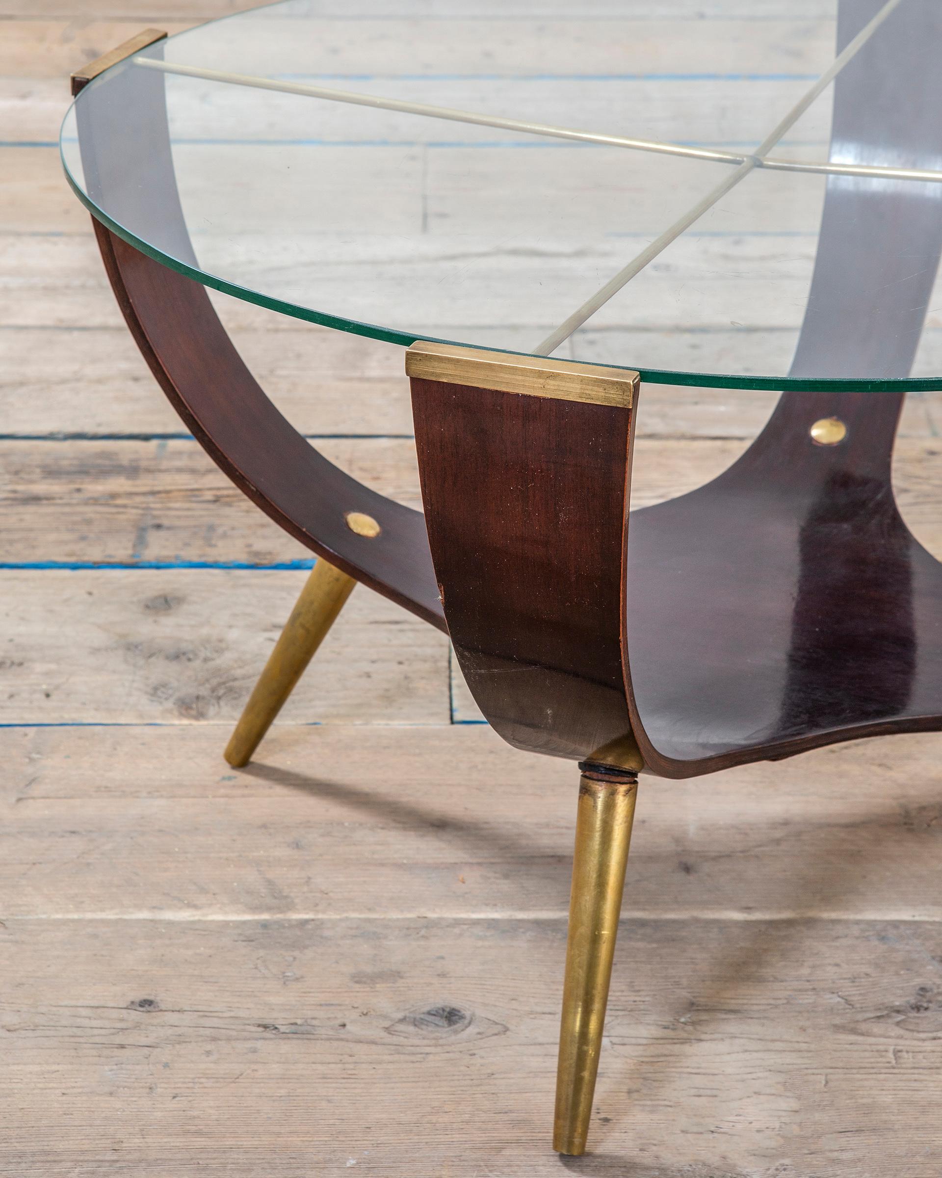 Very beautiful coffee table in the style of Italian School of XXth century. The table has a structure in brass made of 4 feet, the table itself is composed of a part in curved plywood, where you can eventually store some magazines and newspaper or