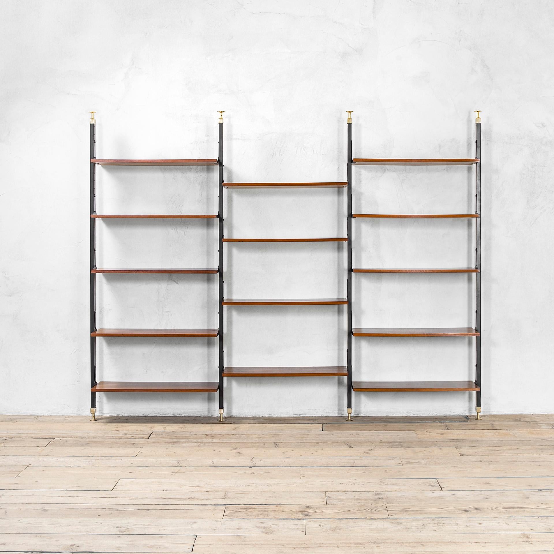 Wall Bookcase composed of 3 bays with height-adjustable shelves. 
Designed and produced in Italy in the 60 s. 
It is realized in lacquered metal structure with brass bases and 14 wooden shelves, that are adjustable. 
Indeed, along the uprights there