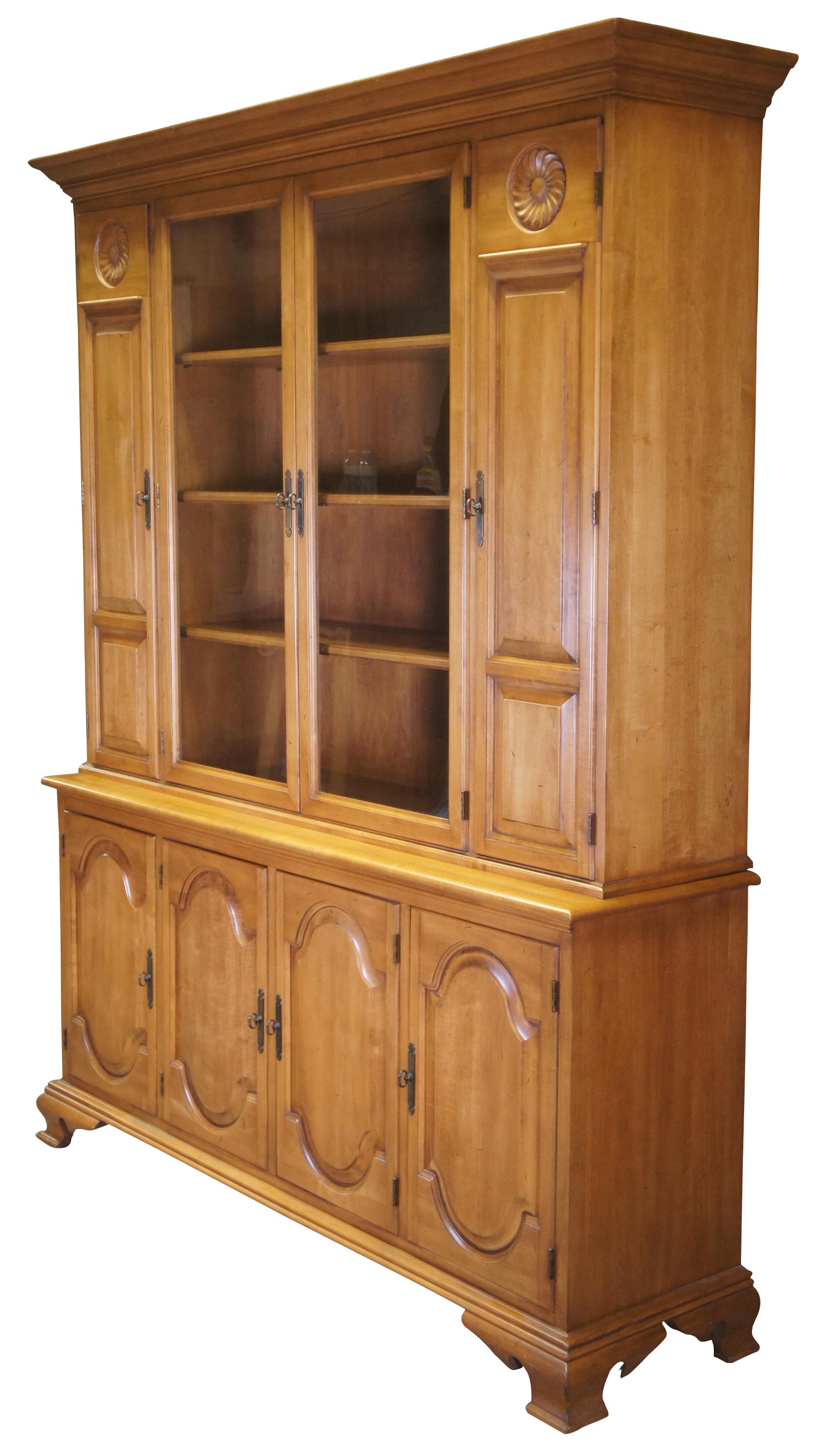 Circa 1970s Italian Provincial China Hutch. Made from walnut with a stepback top with 4 glass covered shelves. Features outer cabinet, lower storage, floral carvings and bracket feet. Measure: 77