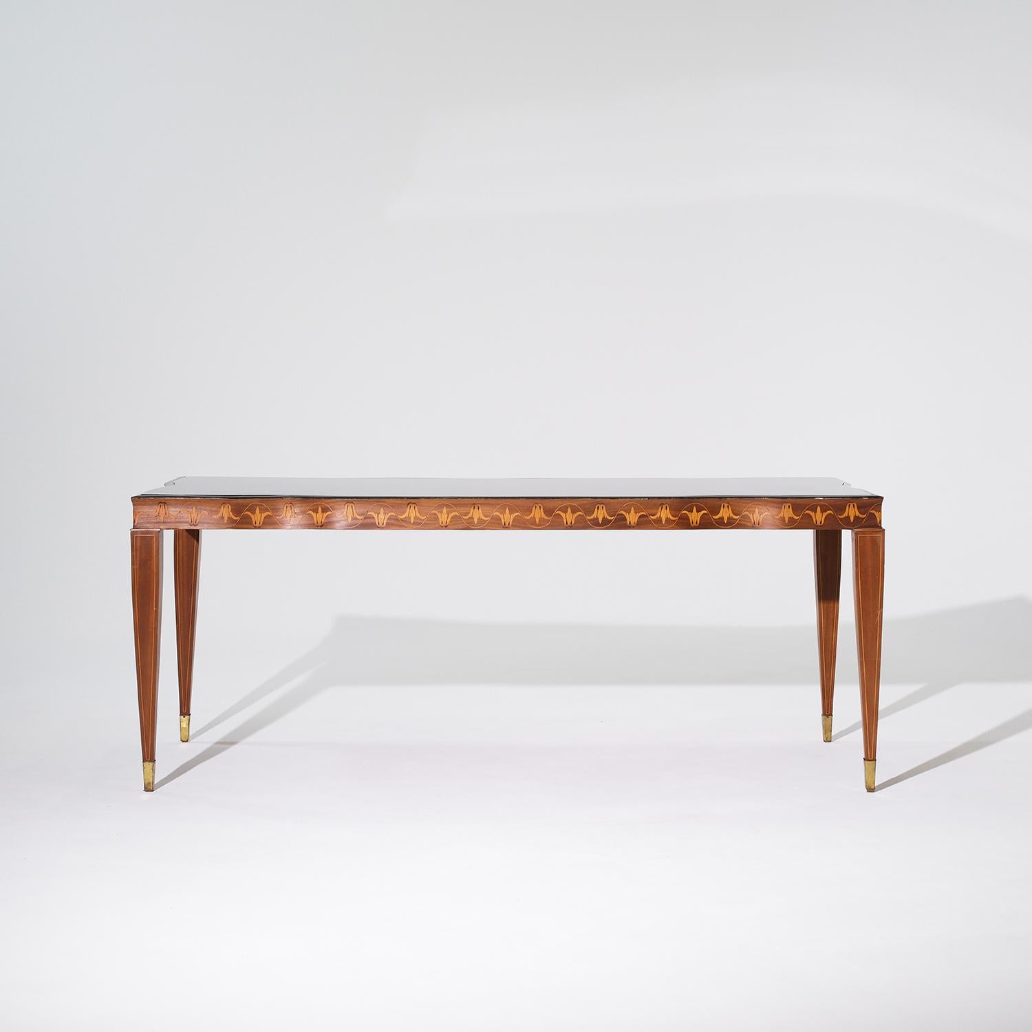 A vintage Mid-Century modern Italian dining room table made of hand crafted polished Rosewood, designed by Paolo Buffa and Serafino Arrighi in good condition. The rectangular conference table is composed with its original smoked black glass top,