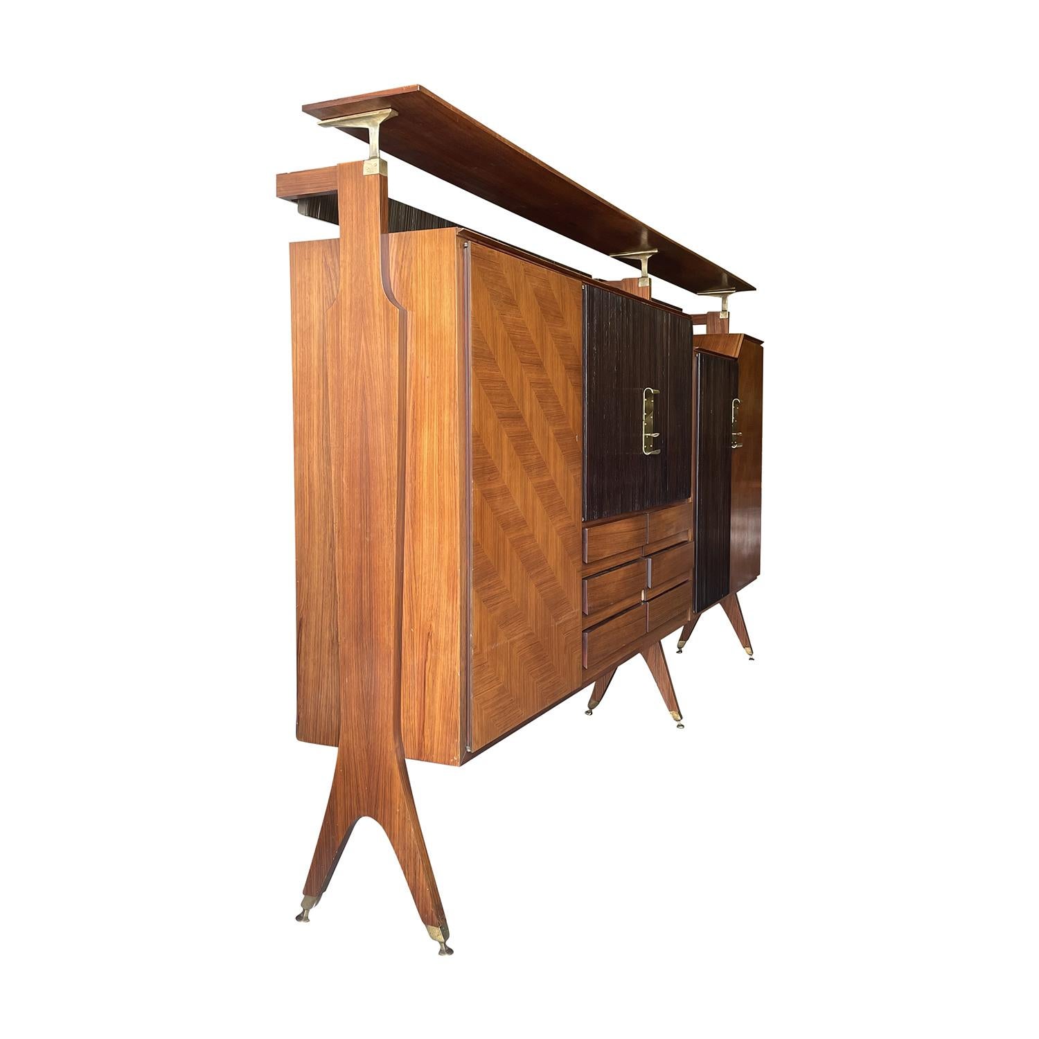 A vintage Mid-Century modern Italian two-part cocktail bar cabinet with an elevated top made of hand crafted polished Rosewood and Walnut, designed by Osvaldo Borsani in good condition. The tall freestanding credenza is composed with six drawers and