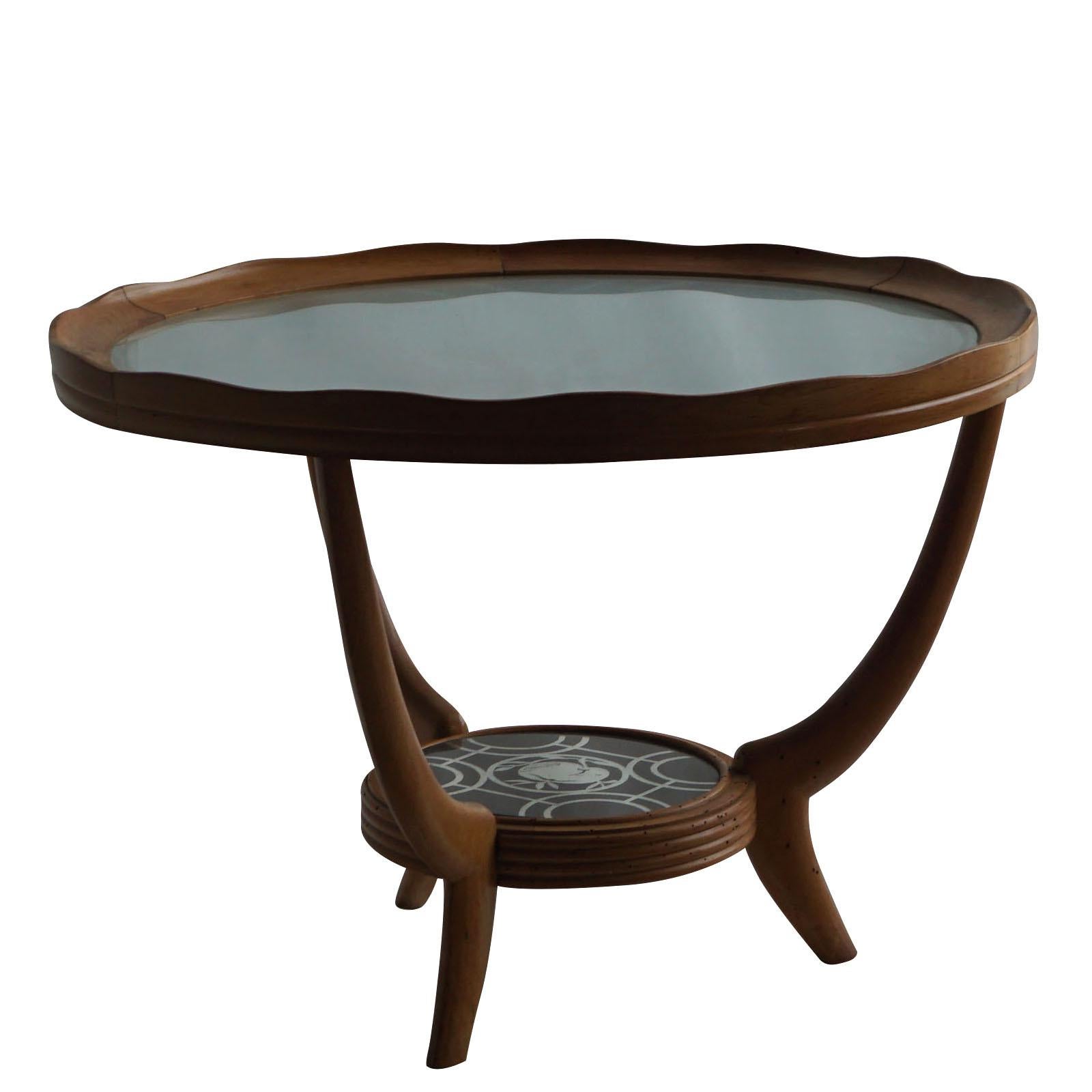 A Mid-Century Modern Italian two-tier side table made of wood with etched glass, in good condition. The upper wooden rim is unevenly carved and refinished in shellac hand polished cherrywood. The small sofa table is enhanced by detailed glass decor,
