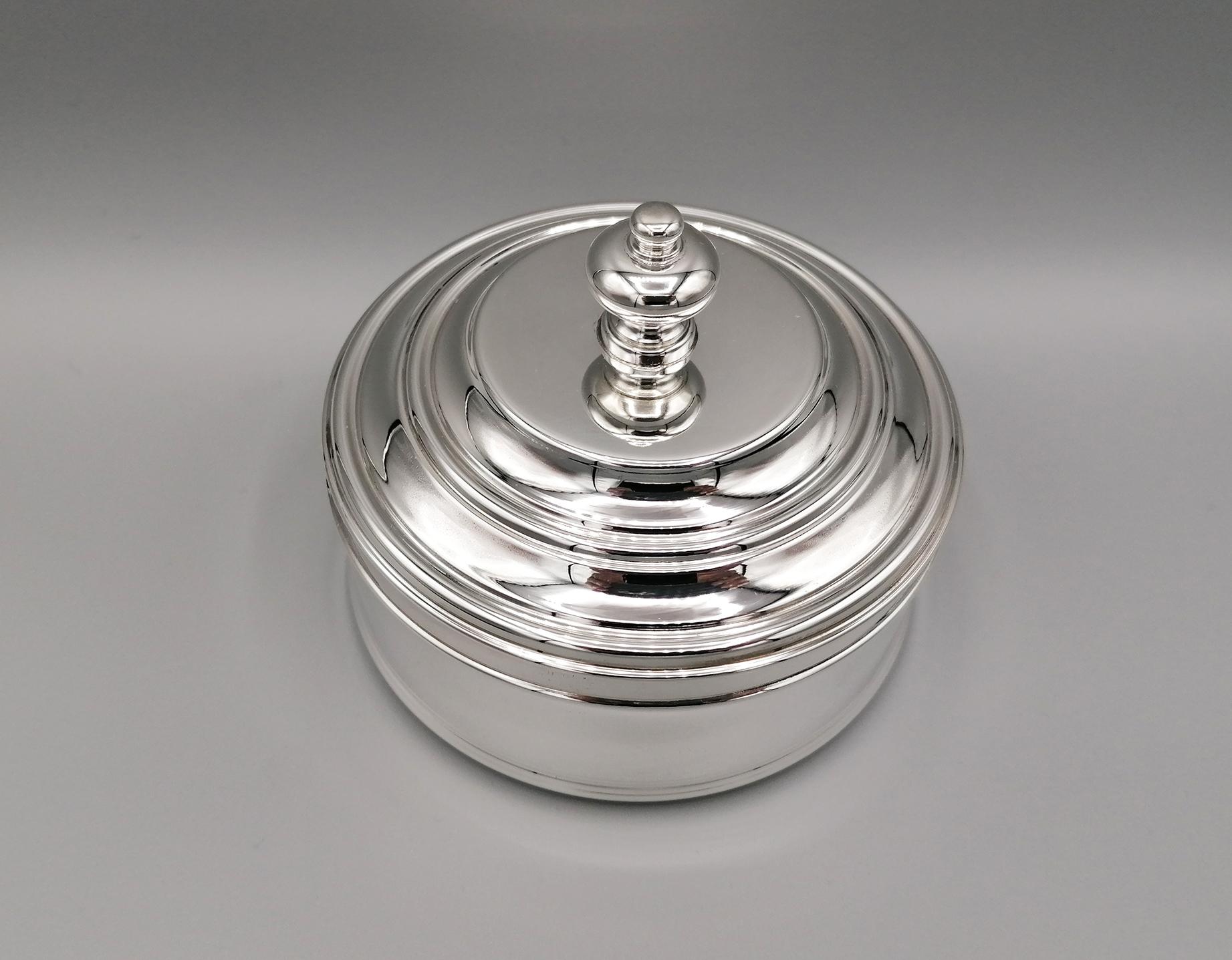 Round shape sterling silver jewelry box. The simplicity of the forms and the harmony of the proportions make it suitable for all settings.
The lid of the jewelry box has a knob handle while the interior is lined with a precious blue fabric with a