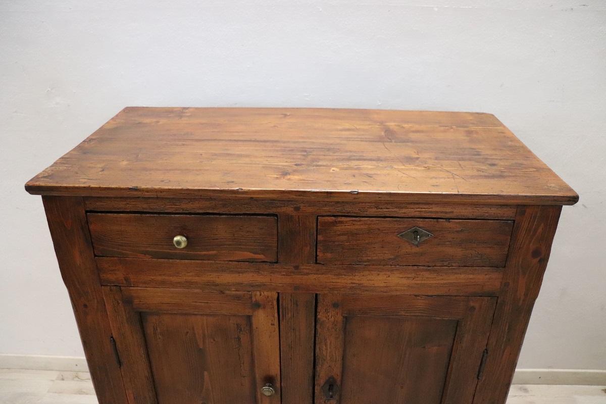 This rustic Italian buffet, crafted from solid fir wood in the first half of the 20th century, embodies simplicity and functionality. Its clean, linear design is free of excessive ornamentation, making it a versatile piece that fits perfectly into
