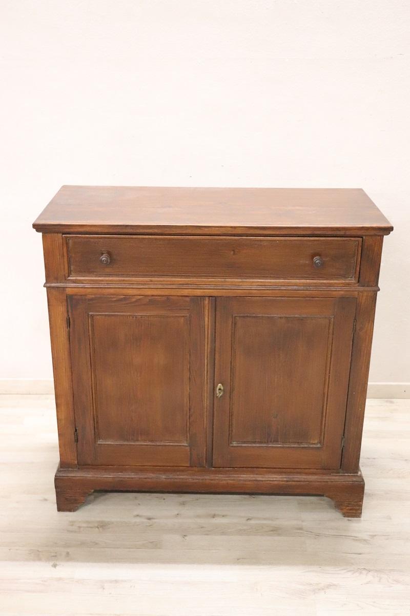 Dieses rustikale italienische Sideboard, das in der ersten Hälfte des 20. Jahrhunderts aus massivem Tannenholz gefertigt wurde, verkörpert Schlichtheit und Funktionalität. Sein klares, geradliniges Design ohne übermäßige Verzierungen macht ihn zu