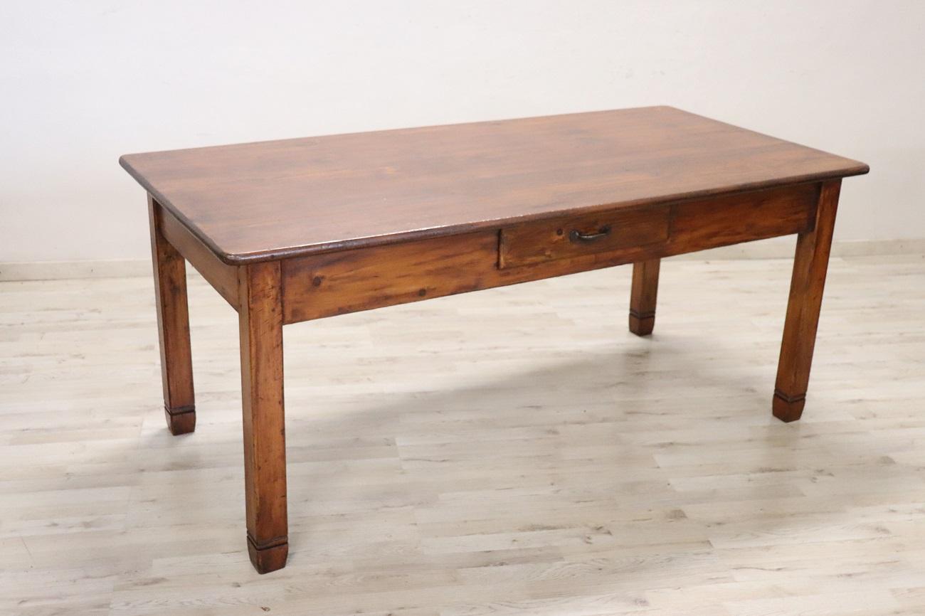 Nous vous présentons cette table rustique italienne de taille considérable, fabriquée au 20e siècle en bois de sapin massif. Son design simple et linéaire comporte un tiroir utile sur la façade, ajoutant à la fois fonctionnalité et charme. Le