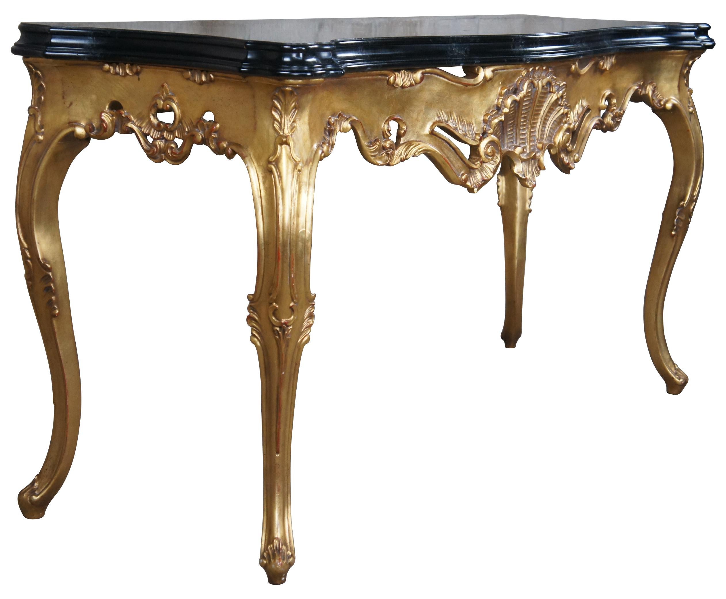 Late 20th century Rococo style console or hall table. Features a serpentine form with faux marble top, a scalloped and pierced giltwood frieze and scalloped legs with acanthus feet. Marked along back side 