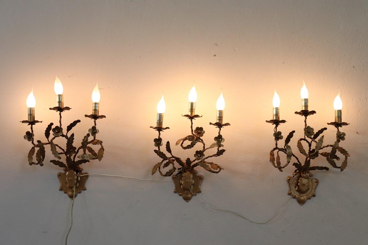 We present an elegant set of three wall lamps made in Italy in the second half of the 20th century. This pair of wall lamps features classic lines with a precious gilded frame, each with three arms holding three light bulbs.

These wall lamps