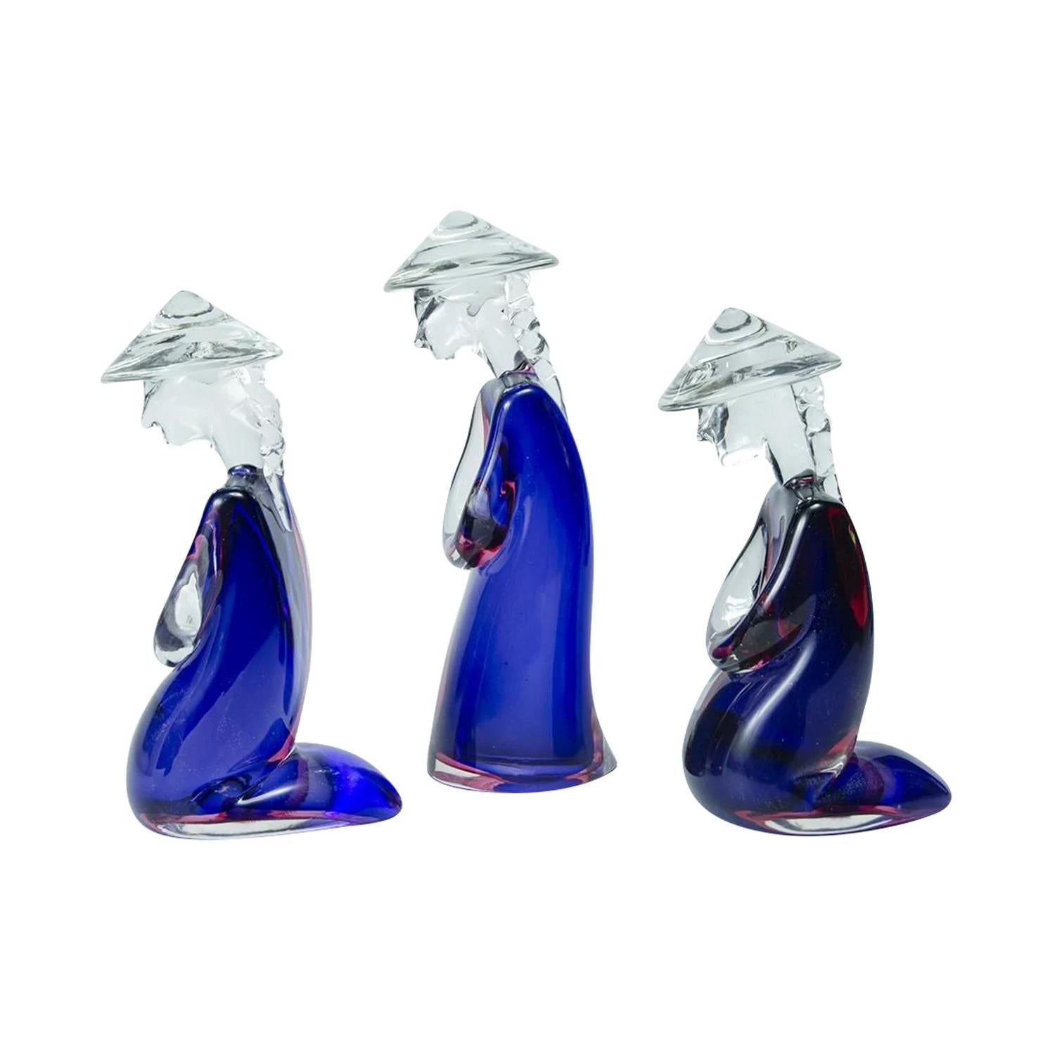 A dark-blue, purple vintage Mid-Century Modern Italian set of three Japanese farmers with a large clear hat made of hand blown colored, smoked Murano Sommerso glass, designed and produced by Archimede Seguso in good condition. The detailed décor