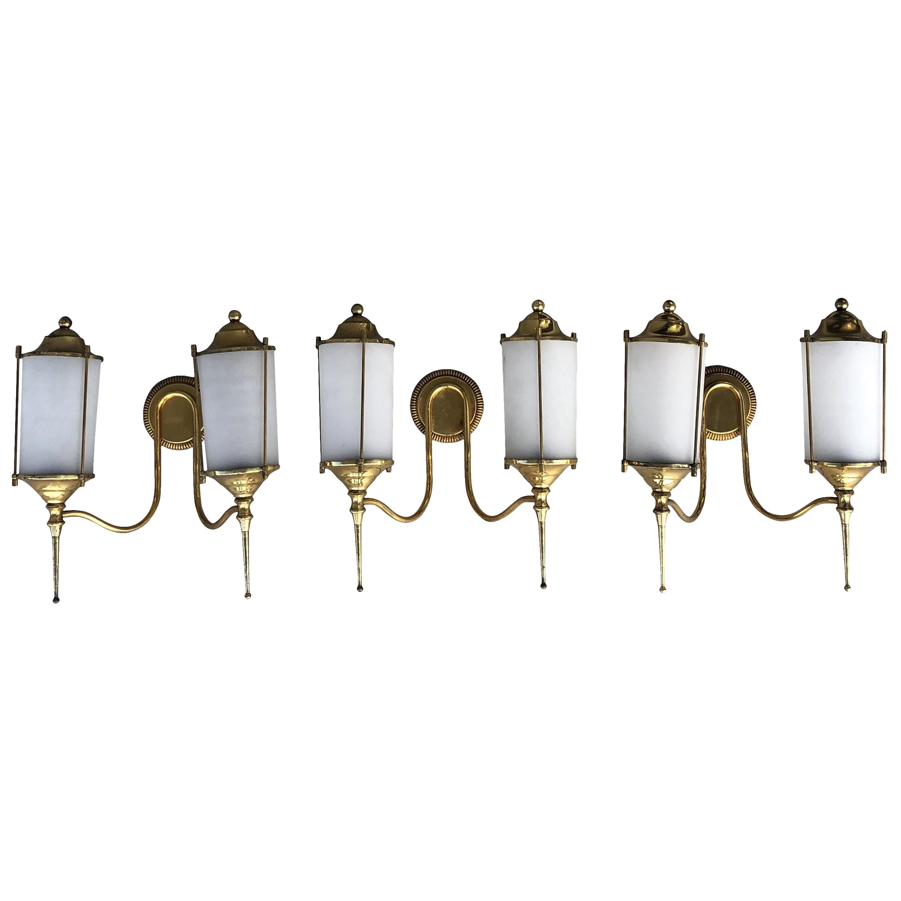 A vintage Mid-Century Modern Italian set of three double light appliques, sconces made of hand crafted brass and hand blown frosted Murano glass, in good condition. Each shade is featuring a one light socket. The wires have been renewed. Wear