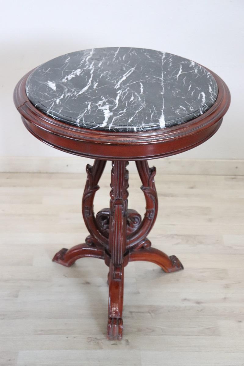 Nous vous proposons cette splendide table d'appoint raffinée, fabriquée en Italie dans les années 1980.

Il présente une forme ronde avec un cadre en bois de hêtre et un plateau en marbre gris foncé raffiné. Les pieds présentent une décoration