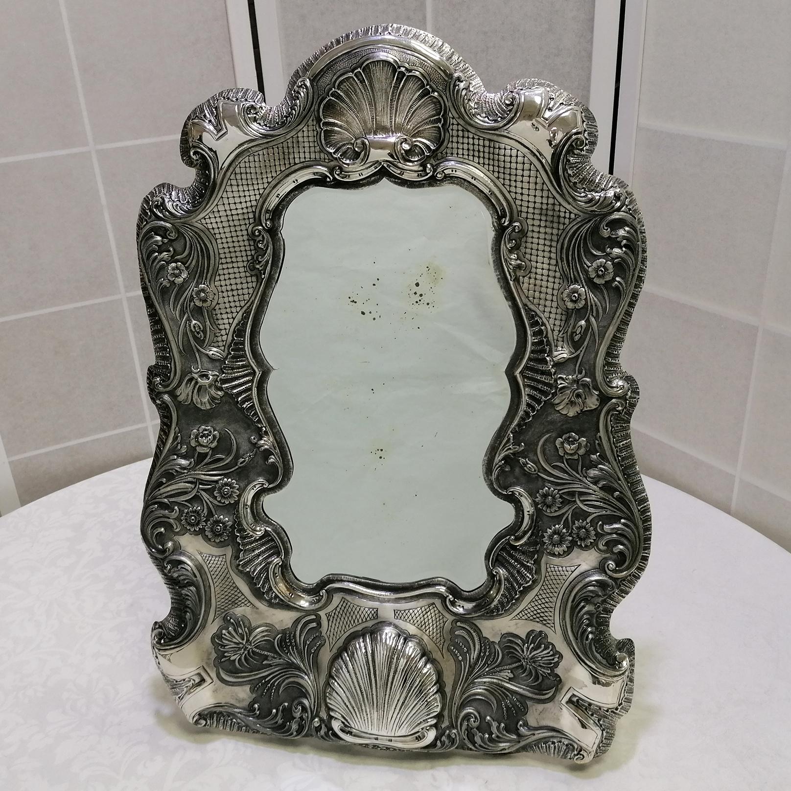 Beeindruckender Barock/Rokoko Wand- und Tischspiegel aus 800er Silber.
Ausgehend von einem antiken Spiegel, der dann in den Spiegel eingesetzt wurde, wurde dieses Meisterwerk komplett von Hand aus einer 800er Silberplatte gefertigt. Anschließend