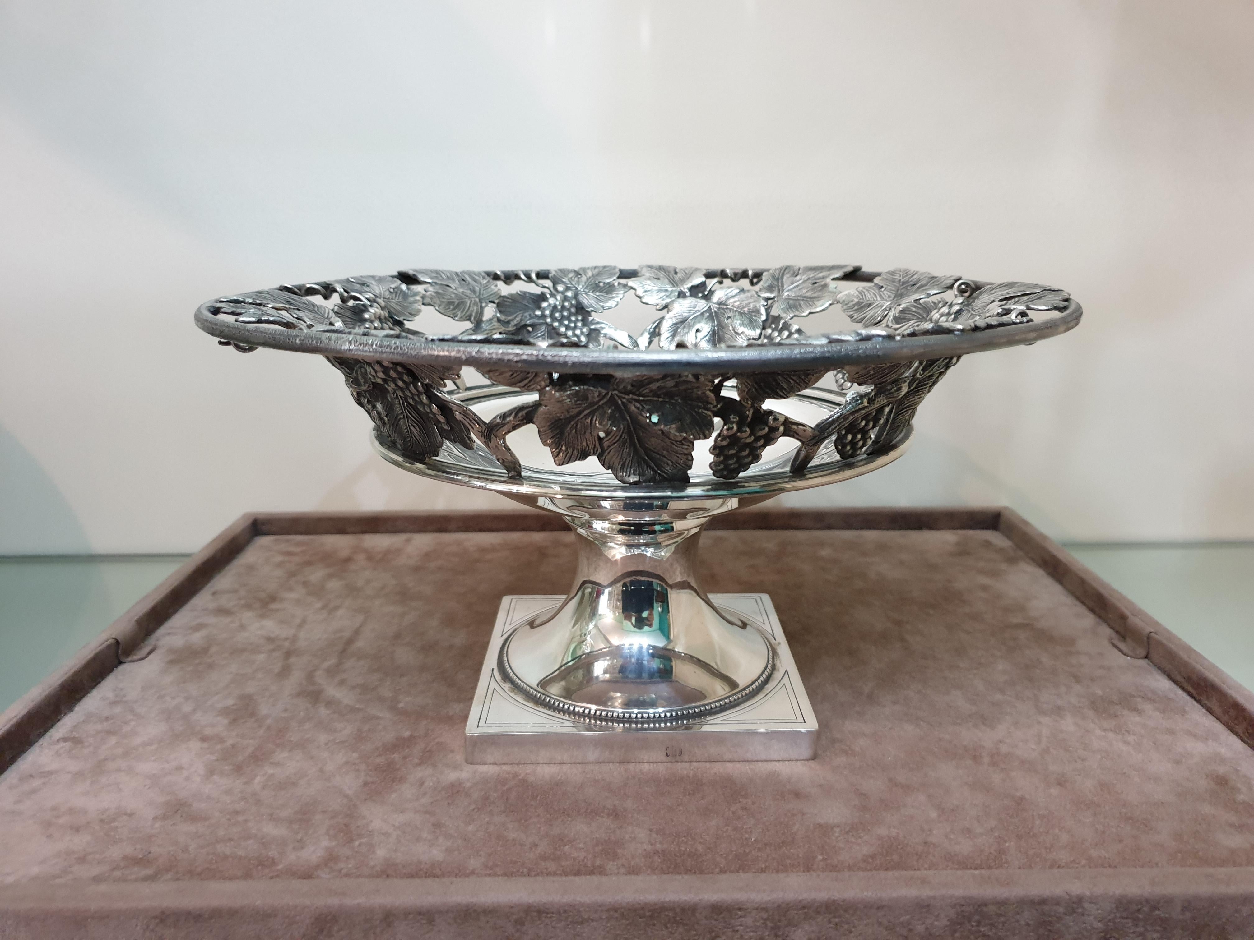 Silver fruit stand realized in Milan, Italy, between 1934 and 1944.
Handcrafted and engraved. Decorated with grape fruits and vines on the top part.
Dimensions: Diameter 27 cm, height 14 cm, weight 1270 gr.