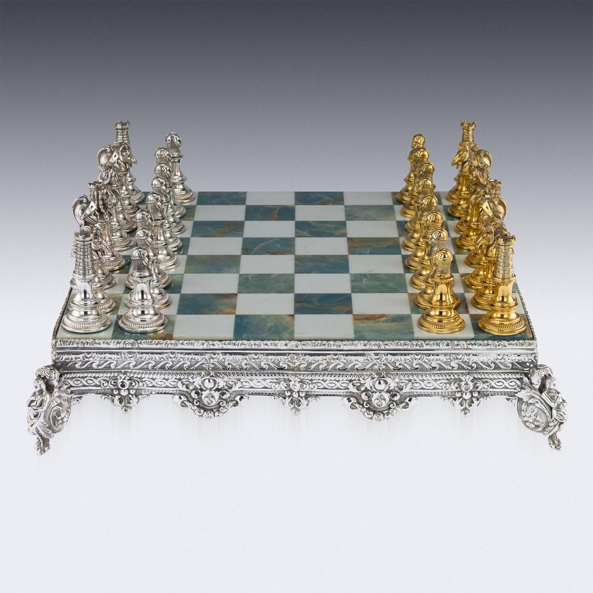Stunning 20th century Italian solid silver chess set pieces on silver plated stand, one set richly gilt, the elaborately decorated board inlaid with blue and white marble. The game pieces hallmarked 