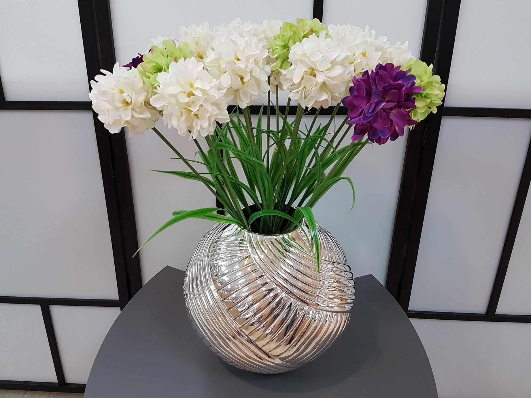 Vase in 800 solid silver.
The round body, made entirely by hand from a flat silver plate and subsequently rounded giving it the characteristic ball shape.
A twisted spiral chiseling was performed all over the body making it very bright and